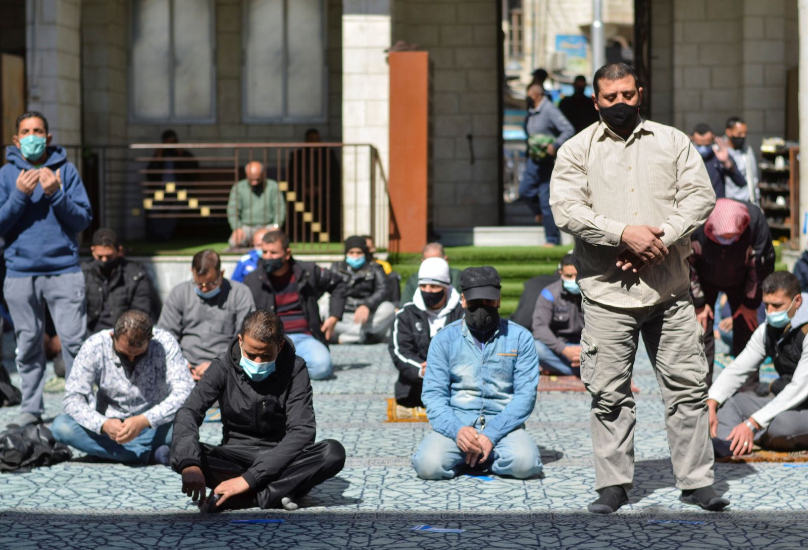 مجموعة من الأشخاص يرتدون كمامات خلال أداء صلاة الجمعة في مسجد الحسيني بالعاصمة الأردنية عمان- 26 فبراير 2021 - REUTERS