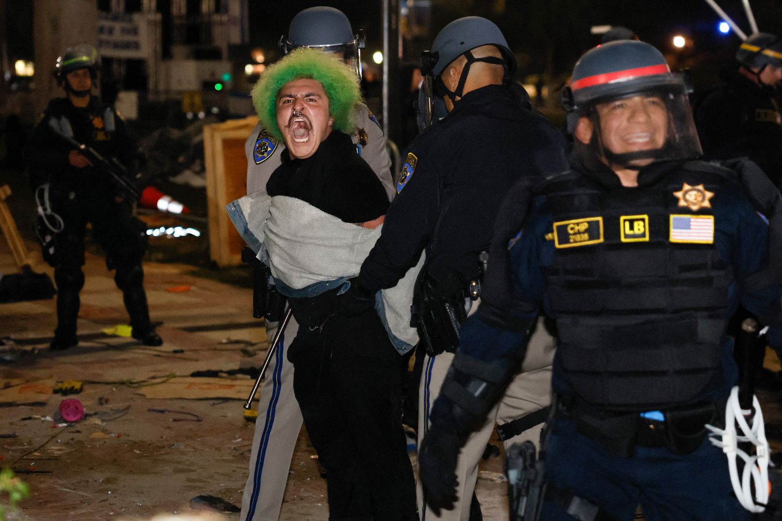 Police make an arrest as they face-off with pro-Palestinian students after destroying part of the encampment barricade on the campus of the University of California, Los Angeles (UCLA) in Los Angeles, California, early on May 2, 2024. Police deployed a heavy presence on US university campuses on May 1 after forcibly clearing away some weeks-long protests against Israel's war with Hamas. Dozens of police cars patrolled at the University of California, Los Angeles campus in response to violent clashes overnight when counter-protesters attacked an encampment of pro-Palestinian students. (Photo by Etienne LAURENT / AFP)