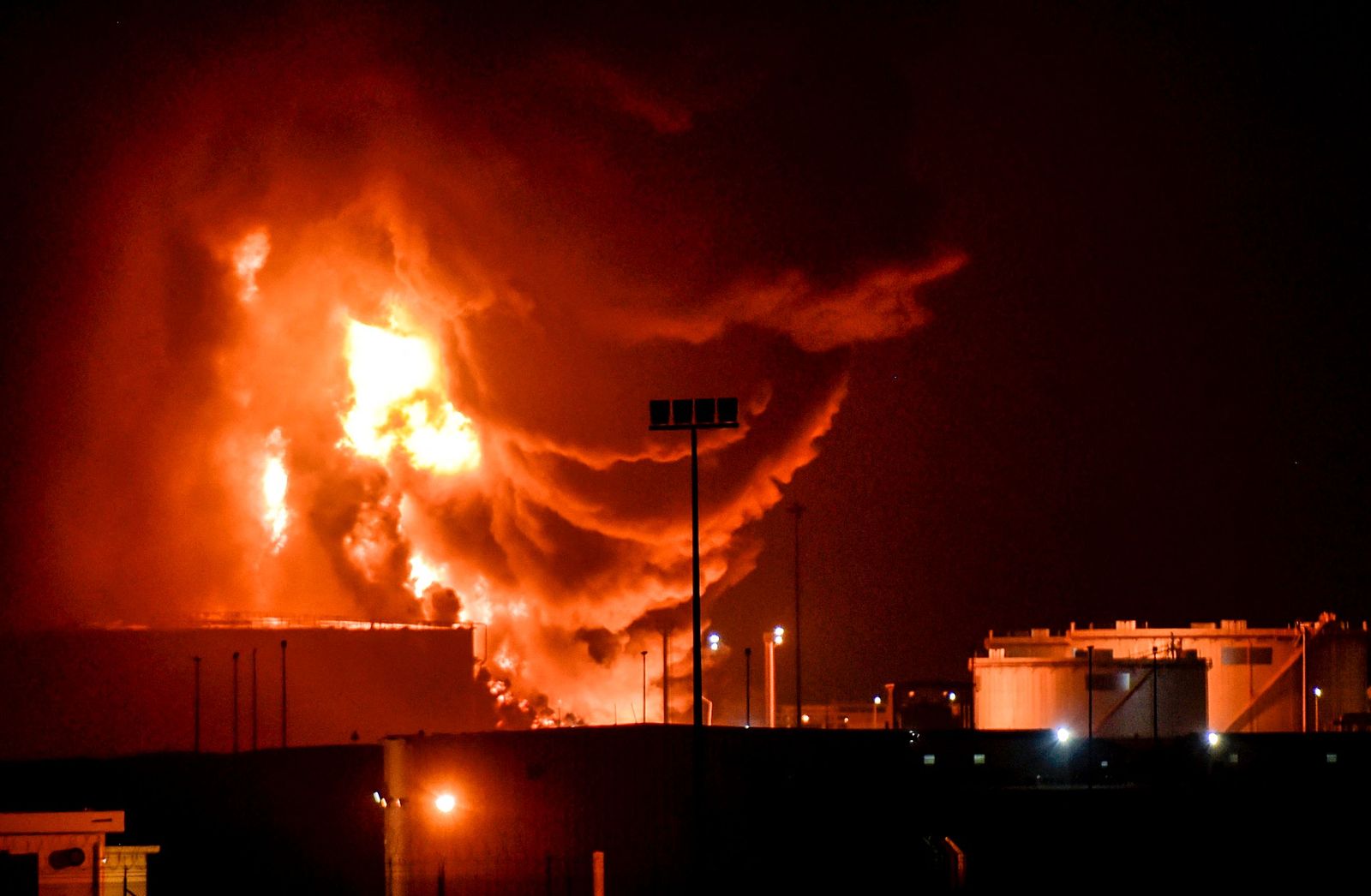 Smoke and flames rise in Saudi Arabia's Red Sea coastal city of Jeddah, on March 25, 2022, following a reported Yemeni rebels attack on a Saudi Aramco oil facility. - Yemeni rebels said they attacked a Saudi Aramco oil facility in Jeddah as part of a wave of drone and missile assaults today as a huge cloud of smoke was seen near the Formula One venue in the city. (Photo by AFP) - AFP