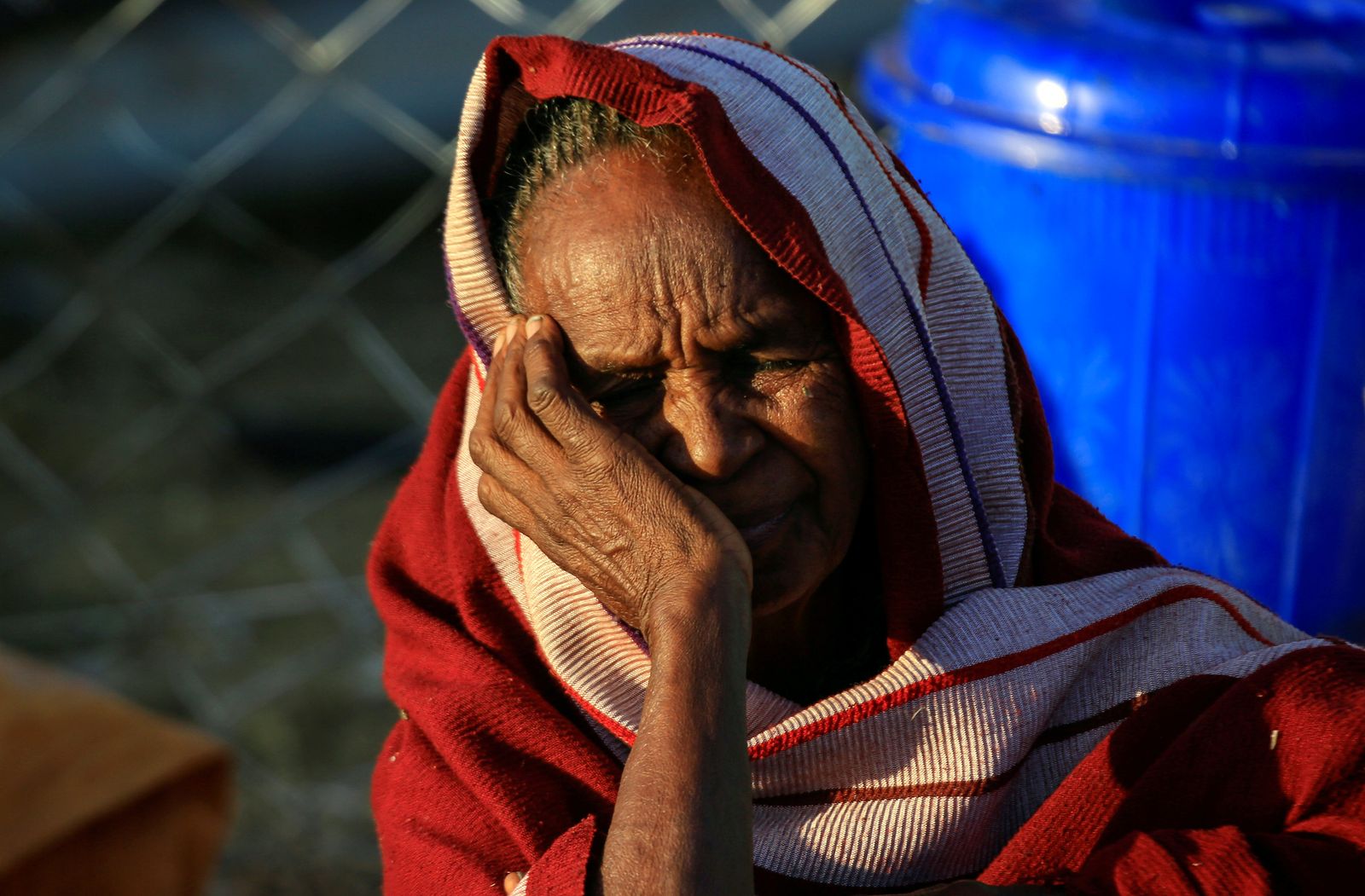 عجوز إثيوبية فارّة من إقليم تيغراي، تنتظر في بلدة سودانية حدودية - 16 ديسمبر 2020 - REUTERS