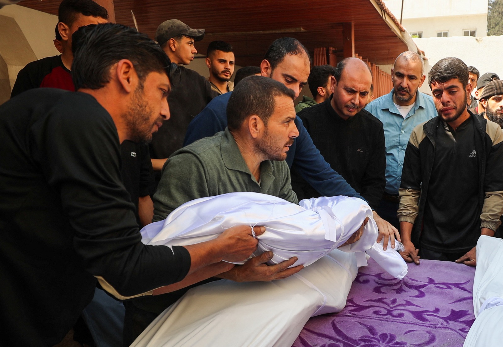 فلسطينيون يحملون جثامين ضحايا القصف الإسرائيلي، في مستشفى المعمداني بمدينة غزة. 7 مايو 2025