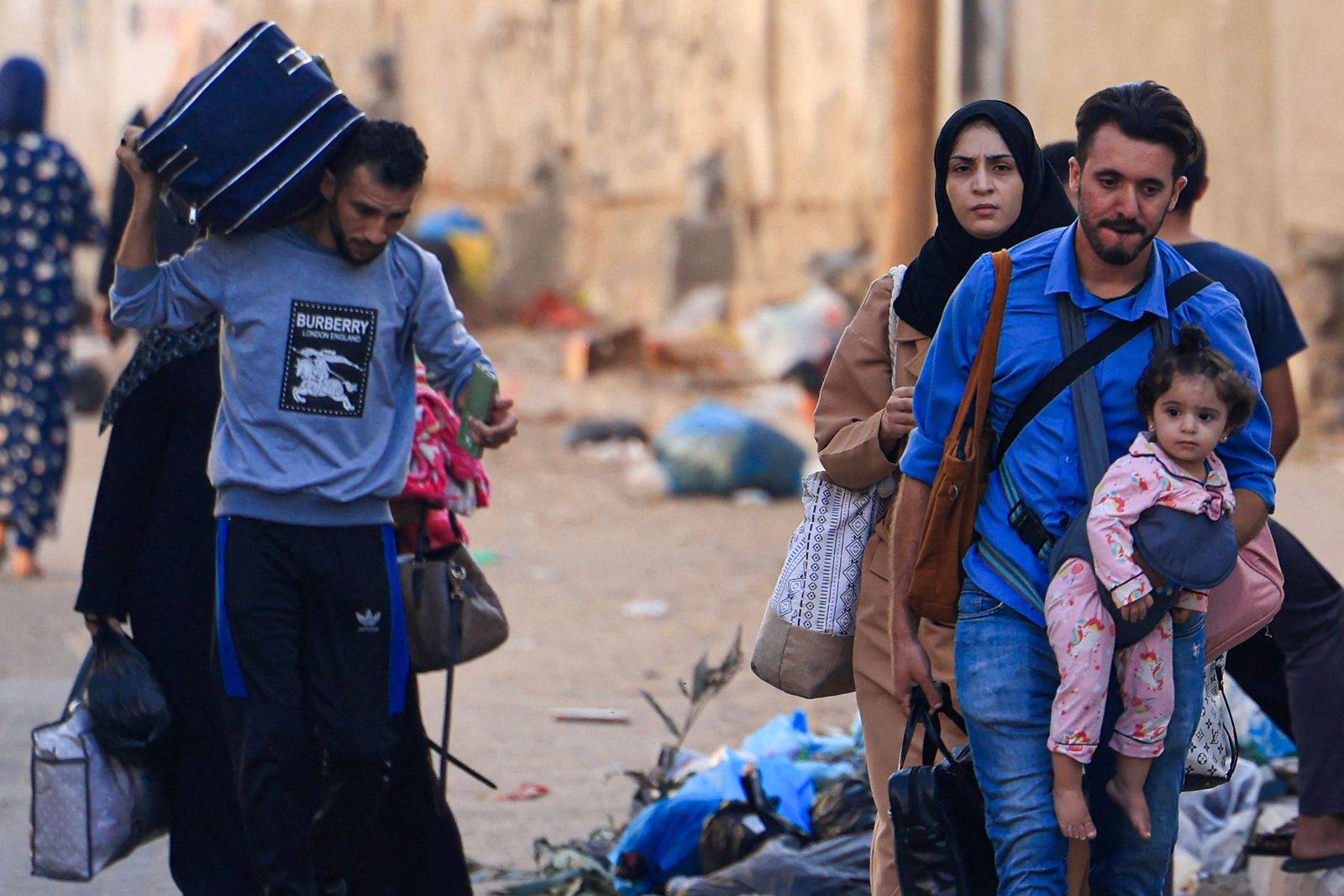 TOPSHOT - Palestinians with their belongings flee from their homes following Israeli airstrikes in Gaza City on October 13, 2023. Israel has called for the immediate relocation of 1.1 million people in Gaza amid its massive bombardment in retaliation for Hamas's attacks, with the United Nations warning of 'devastating' consequences. (Photo by Mahmud Hams / AFP)