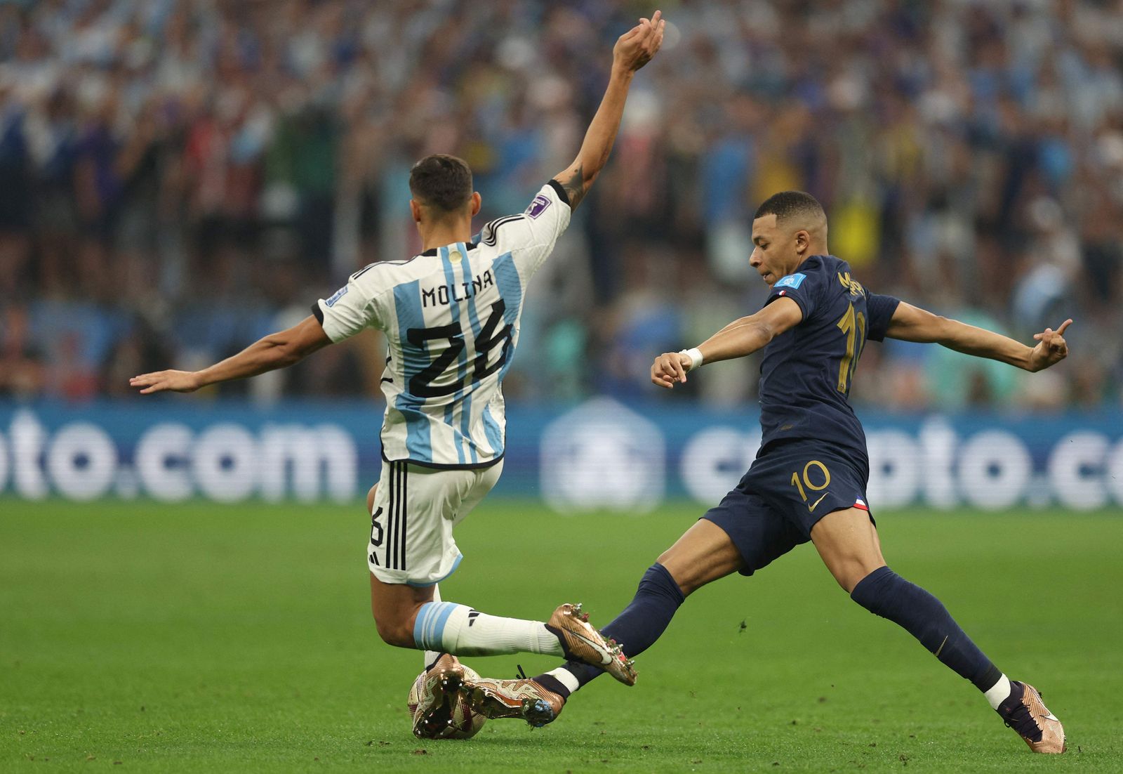 Argentina's defender #26 Nahuel Molina (L) tackles France's forward #10 Kylian Mbappe during the Qatar 2022 World Cup final football match between Argentina and France at Lusail Stadium in Lusail, north of Doha on December 18, 2022. (Photo by Adrian DENNIS / AFP) - AFP