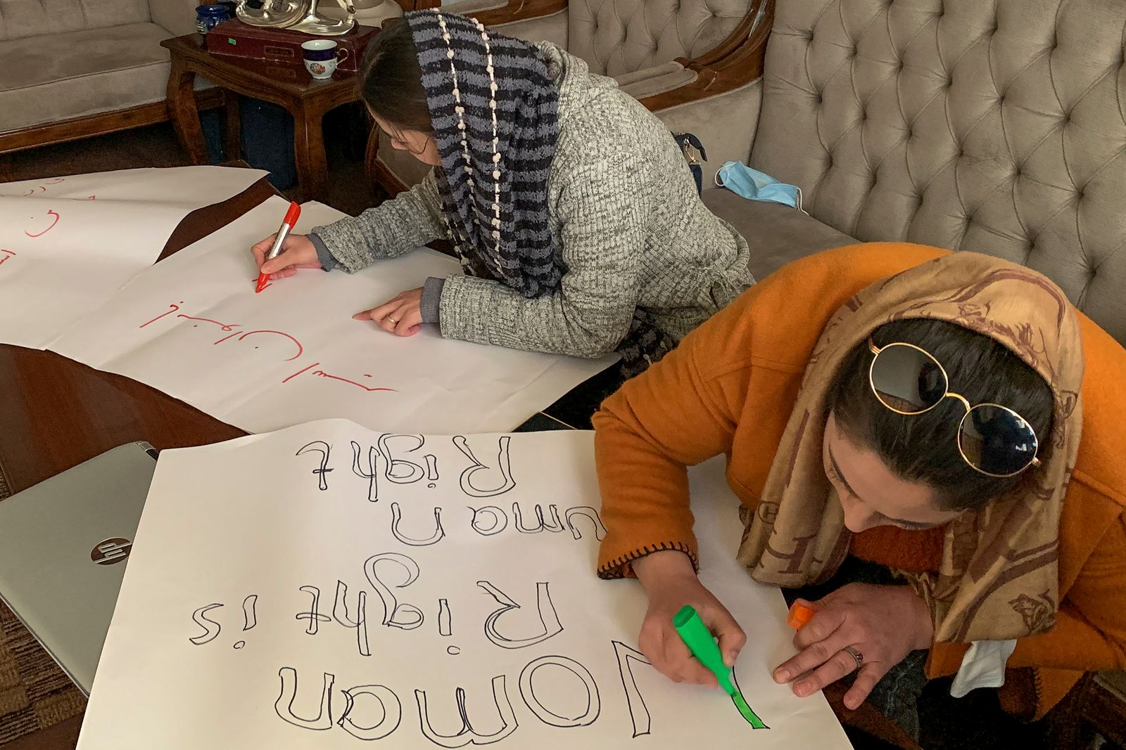 نساء أفغانيات يخططن لافتات قبل مسيرة احتجاجية لحقوق المرأة في العاصمة كابول -  15 يناير 2022  - AFP