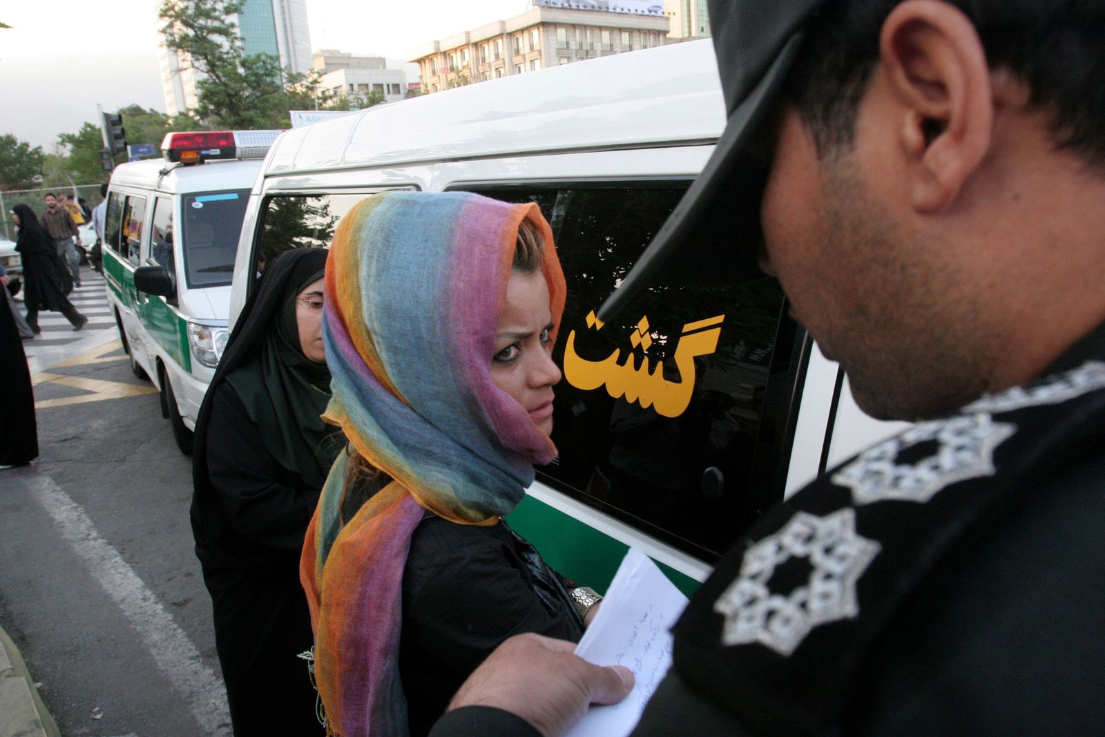 عنصر من شرطة الأخلاق الإيرانية يحرر اسم سيدة اعتقلها في أحد شوارع طهران- 18 يونيو 2008 - REUTERS