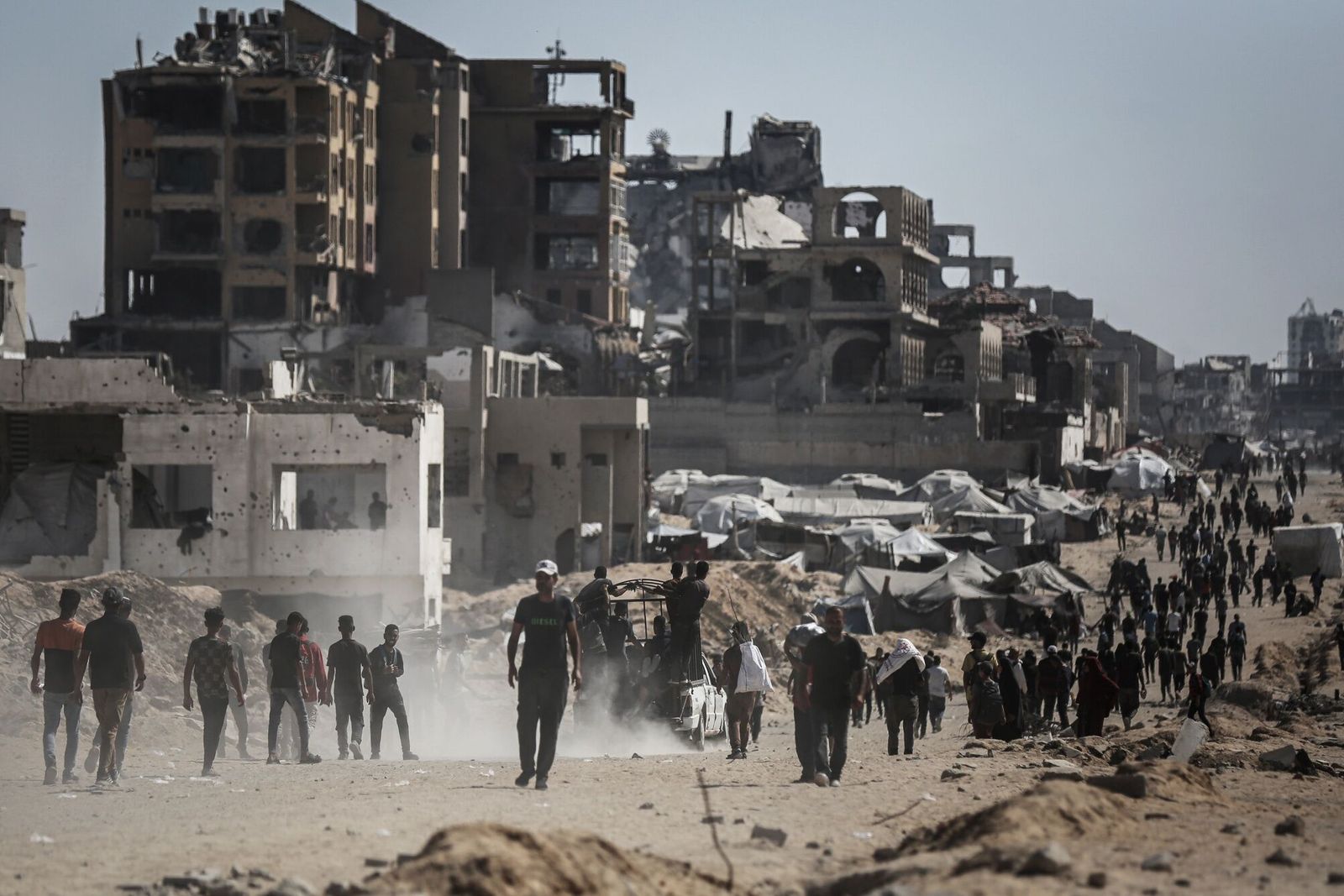 Palestinians gather to collect humanitarian aid from a distribution point in Beit Lahia, northern Gaza, on Sunday, July 20, 2025. Israel shuttered traditional aid distribution channels in favor of a US-backed alternative, known as the Gaza Humanitarian Foundation (GHF), which it argued would help sideline Hamas. Photographer: Ahmad Salem/Bloomberg