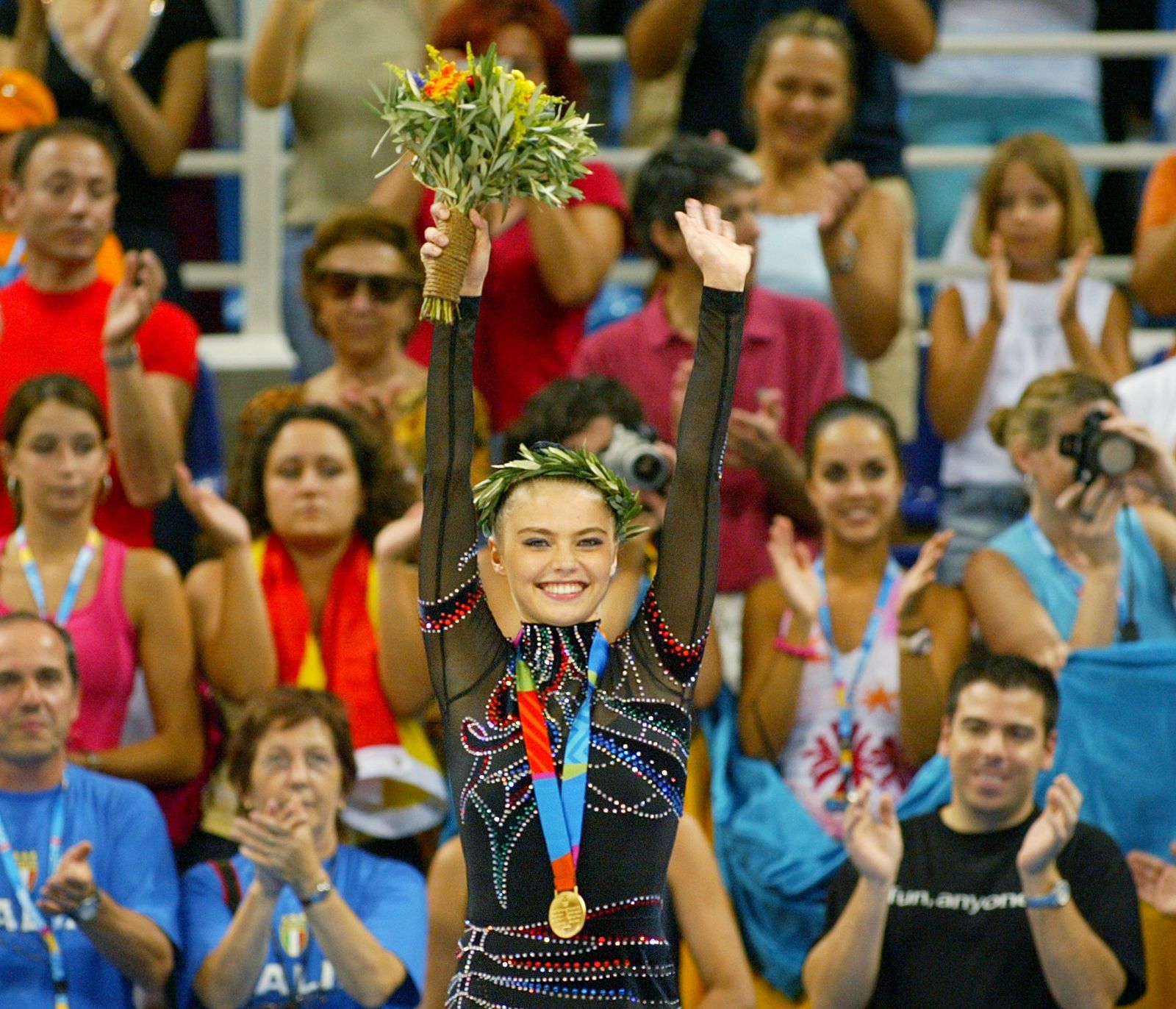 ألينا كابيفا الحائزة على الميدالية الذهبية الروسية تلوح بينما يصفق لها المتفرجون خلال حفل الميدالية للنهائي الشامل للسيدات في مسابقة الجمباز الإيقاعي في دورة أثينا للألعاب الأولمبية. 29 أغسطس 2004 - REUTERS