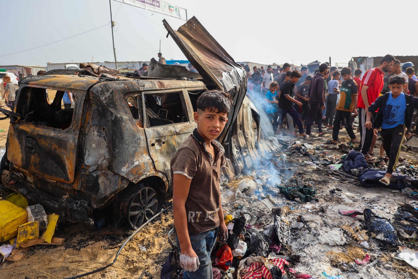 EDITORS NOTE: Graphic content / TOPSHOT - Palestinians gather at the site of an Israeli strike on a camp area housing internally displaced people in Rafah on May 27, 2024, amid ongoing battles between Israel and the Palestinian Hamas militant group. Hamas and the Palestinian Authority said Israeli strikes on a centre for displaced people killed dozens near the southern city of Rafah on May 26, while the Israeli army said it had targeted Hamas militants. (Photo by Eyad BABA / AFP)