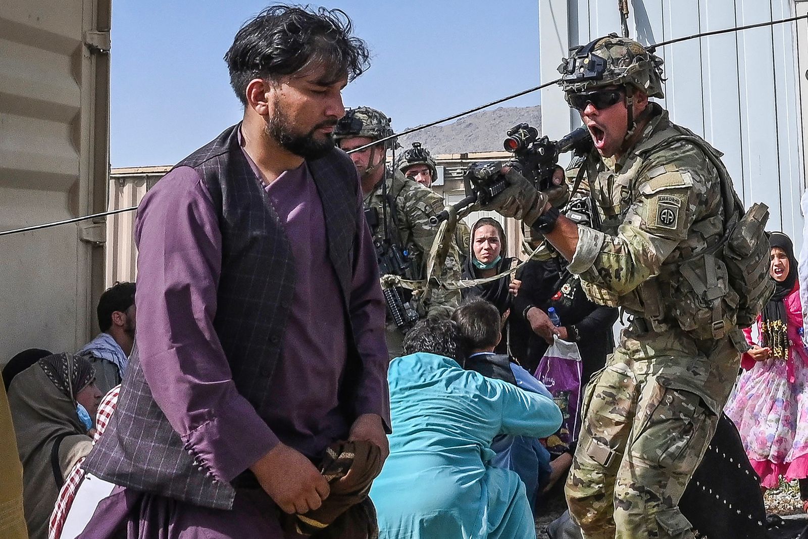 جندي أميركي يوجه سلاحه نحو مسافر أفغاني في مطار كابول - 16 أغسطس 2021 - AFP