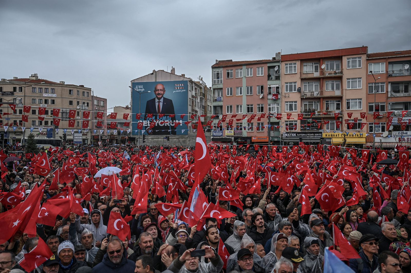 Supporters wave Turkish national flags as they attend a rally of Turkey's Republican People's Party (CHP) Chairman and Presidential candidate Kemal Kilicdaroglu in Canakkale, western Turkey, on April 11, 2023. - A sea of umbrellas and hoods at his feet, Kemal Kilicdaroglu, the Turkish opposition candidate who will challenge Recep Tayyip Erdogan at the polls on 14 May, smilingly promises 