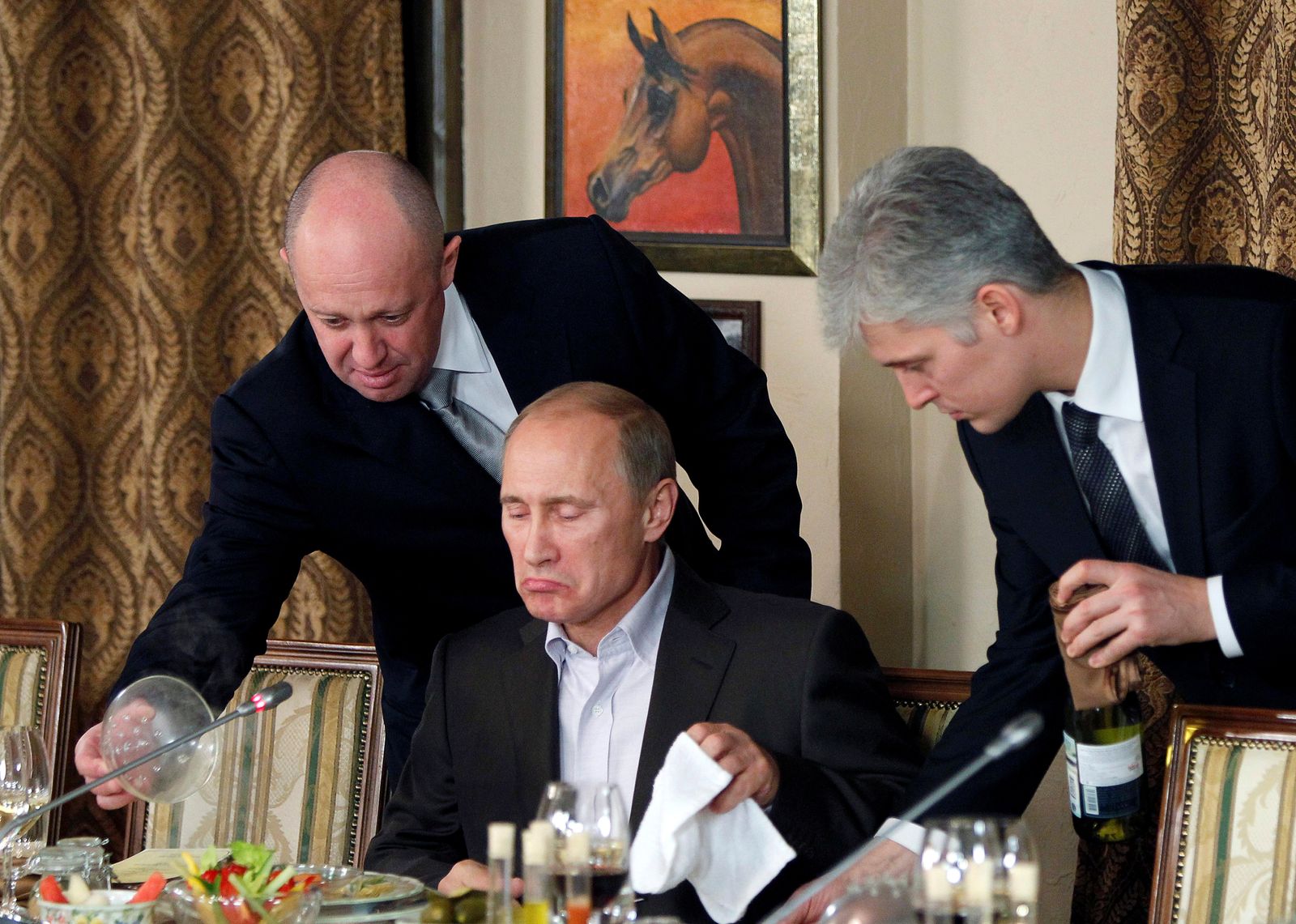 إيفجيني بريجوزين (يسار) يساعد فلاديمير بوتين حينما كان رئيساً للوزراء خلال مأدبة عشاء في مجمع للفروسية خارج موسكو. 11 نوفمبر 2011 - REUTERS