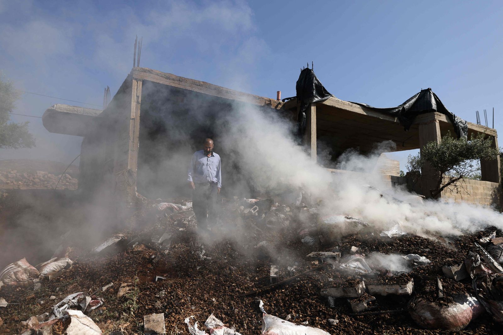 A Palestinian inspects the damage to a home in the village of Mughayir near Ramallah in the Israeli-occupied West Bank on April 13, 2024, after an attack by Israeli settlers on the village. (Photo by JAAFAR ASHTIYEH / AFP)