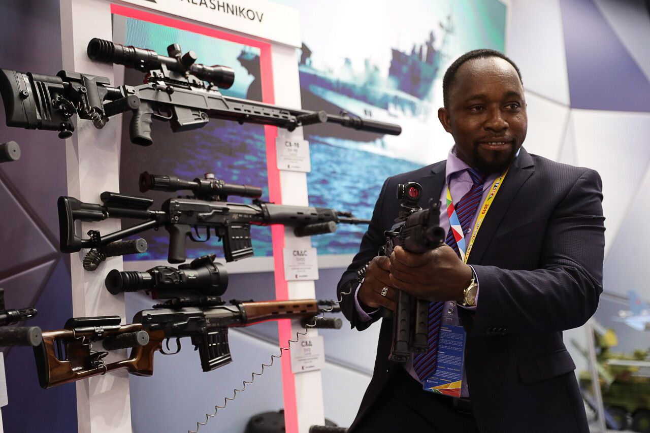 عضو بأحد الوفود الأفريقية المشاركة في قمة روسيا أفريقيا يختبر أحد الأسلحة بمعرض على هامش القمة في سوتشي 2019 - TASS