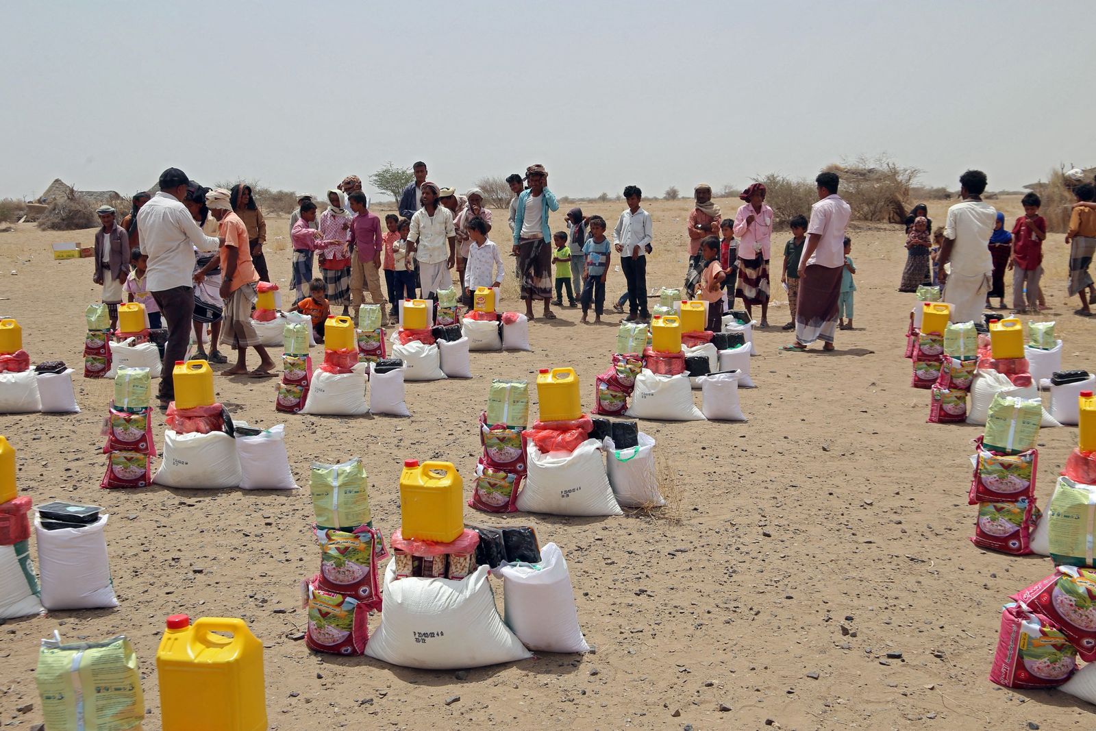 Yemenis displaced by the conflict, receive food aid and supplies to meet their basic needs, at a camp in Hays district in the war-ravaged western province of Hodeidah on March 29, 2022, as food prices have doubled since last year and the fact that Ukraine supplies nearly a third of Yemen's wheat imports has heightened fears of a deepening famine. - The disruption in export flows resulting from Russia's invasion and international sanctions has spurred fears of a global hunger crisis, especially across the Middle East and Africa, where the knock-on effects are already playing out. The toll is most evident in conflict zones such as Yemen, the Arab world's poorest, where a devastating war since 2014 has sparked one of the world's worst humanitarian crises. (Photo by Khaled Ziad / AFP) - AFP