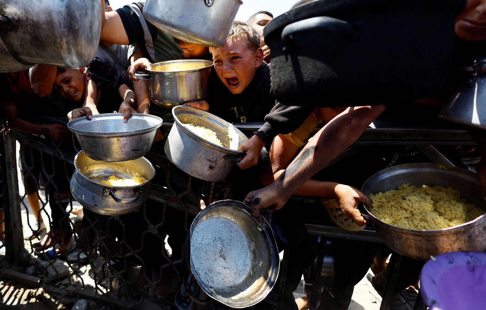 Palestinians wait to receive food from a charity kitchen after the global hunger monitor, Integrated Food Security Phase Classification (IPC), said that Gaza City and surrounding areas are officially suffering from famine that will likely spread, in Gaza City, August 28, 2025. REUTERS/Mahmoud Issa