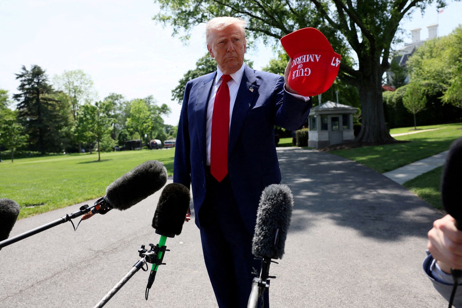 U.S. President Donald Trump holds a cap with the words 'Gulf of America' embroidered as he speaks to the media before boarding Marine One to depart for Michigan to attend a rally to celebrate his first 100 days in office, from the South Lawn of the White House in Washington, D.C., U.S., April 29, 2025. REUTERS/Leah Millis