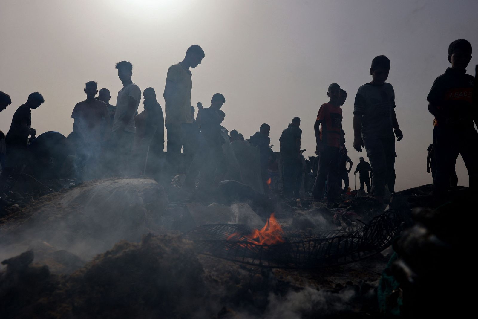 Palestinians gather at the site of an Israeli strike on a camp for internally displaced people in Rafah on May 27, 2024, amid ongoing battles between Israel and the Palestinian Hamas militant group. The Palestinian Authority and the militant group Hamas said Israeli strikes on a centre for displaced people killed dozens near the southern city of Rafah on May 26, while the Israeli army said it had targeted Hamas militants. (Photo by Eyad BABA / AFP)