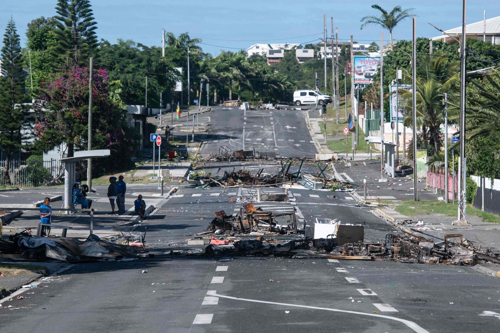 A street blocked by debris and burnt out items is seen following overnight unrest in the Magenta district of Noumea, France's Pacific territory of New Caledonia, on May 18, 2024. Hundreds of French security personnel tried to restore order in the Pacific island territory of New Caledonia on May 18, after a fifth night of riots, looting and unrest. (Photo by Delphine Mayeur / AFP)