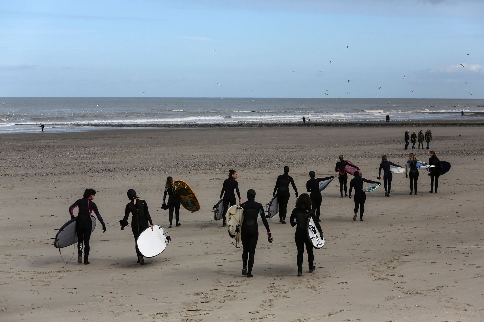 فريق North Sea Surf Sisters يتجهن نحو البحر في أوستند- بلجيكا في 11 مارس 2023. - AFP