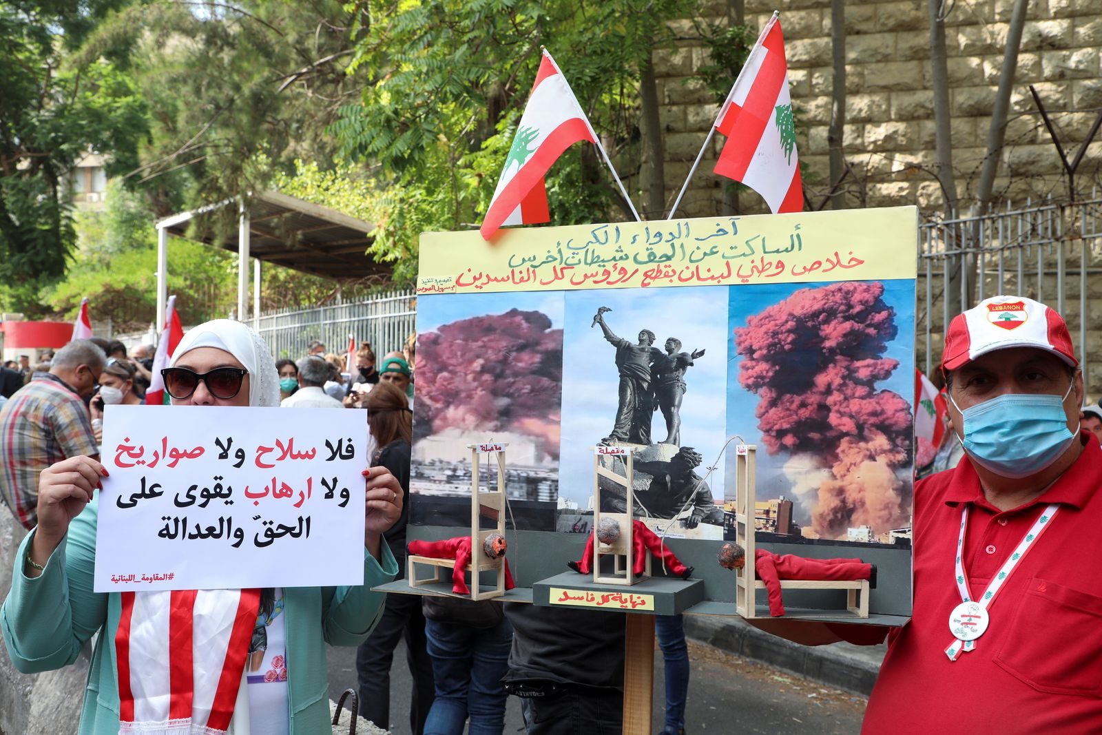 متظاهرون يرفعون لافتات تندد بتعليق التحقيق في انفجار ميناء بيروت، لبنان، 29 سبتمبر 2021 - REUTERS
