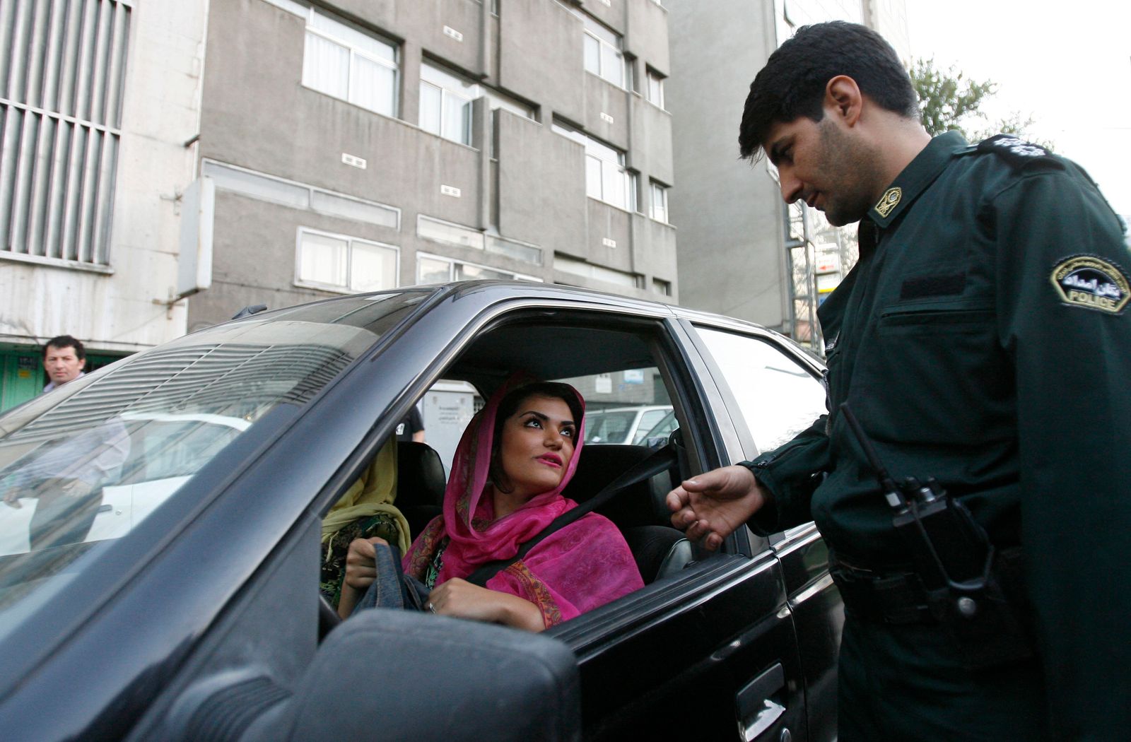 عنصر من شرطة الأخلاق يطلب من سيدة هويتها في نقطة تفتيش بالعاصمة الإيرانية طهران- 16 يونيو 2008 - REUTERS