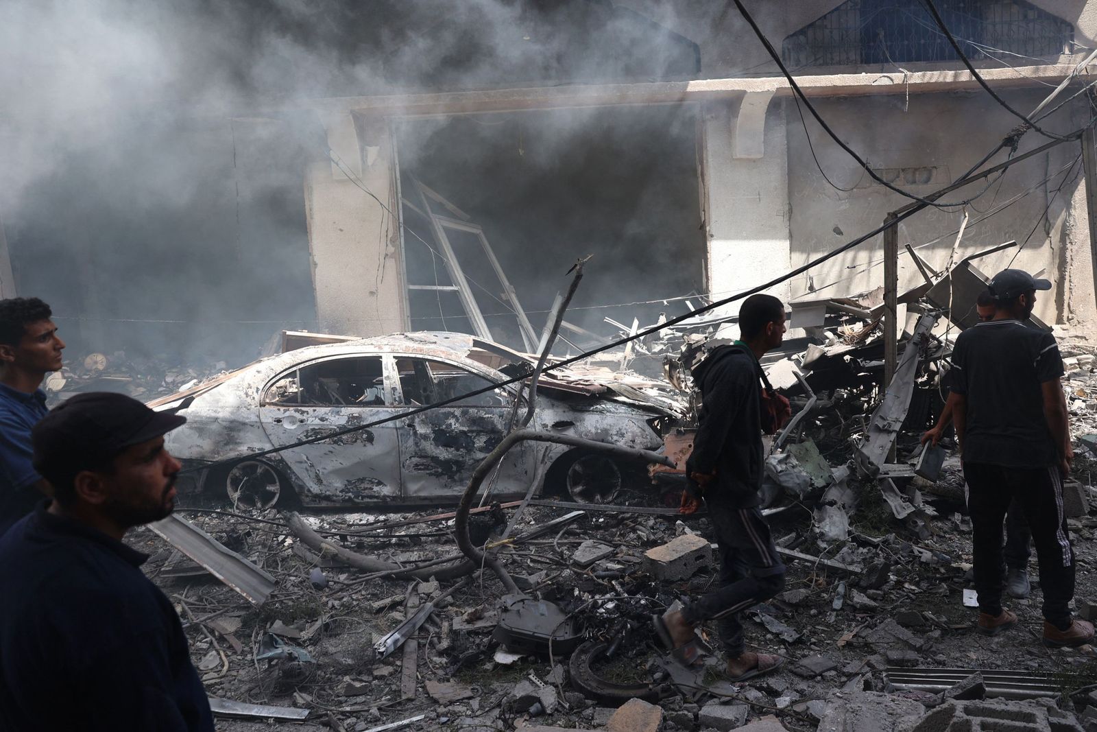 Palestinian men look at the destruction following an operations by the Israeli Special Forces in the Nuseirat camp, in the central Gaza Strip on June 8, 2024, amid the ongoing conflict between Israel and the Palestinian Hamas militant group. The Israeli military said in a statement on June 8, that their forces were 'targeting terrorist infrastructure in the area of Nuseirat'. A Gaza hospital said the Israeli strikes in central areas of the territory, including in Nuseirat camp, killed at least 15 people. (Photo by Eyad BABA / AFP)