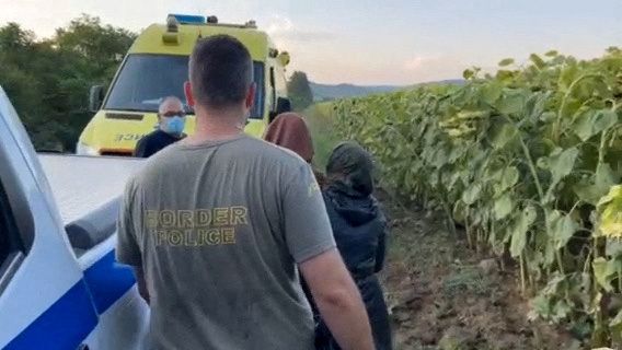 Migrants are escorted by a Greek border police officer, in the region of Evros - REUTERS