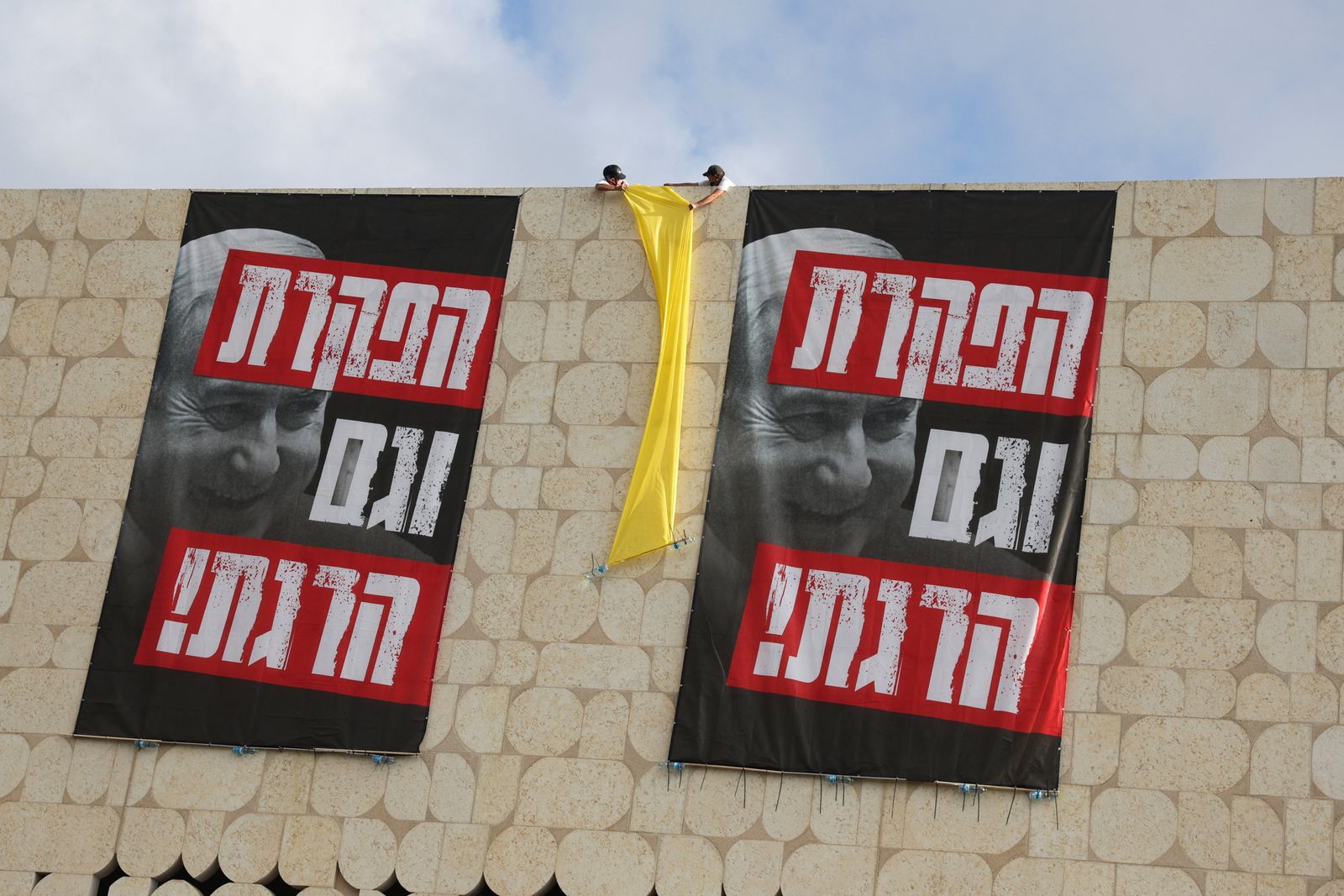 People hold a yellow cloth between signs that read, 'You abandoned and also killed' on the day of a protest demanding the immediate release of the hostages kidnapped during the deadly October 7, 2023 attack on Israel by Hamas, in Jerusalem, September 3, 2025. REUTERS/Ronen Zvulun