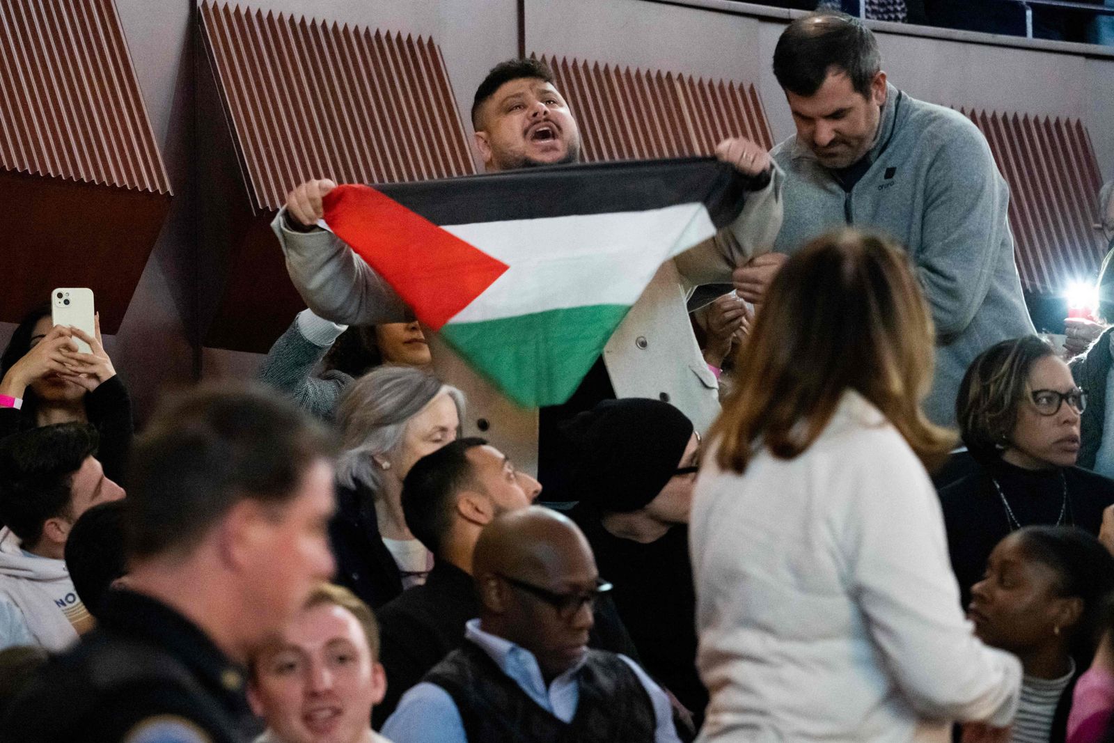 A pro-Palestinian protestor shouts in support of Gaza as US President Joe Biden speaks during a campaign rally to Restore Roe at Hylton Performing Arts Center in Manassas, Virginia, on January 23, 2024. Protesters chanting slogans against Israel's offensive in Gaza repeatedly interrupted US President Joe Biden on Tuesday during an election campaign event to promote abortion rights. (Photo by SAUL LOEB / AFP)