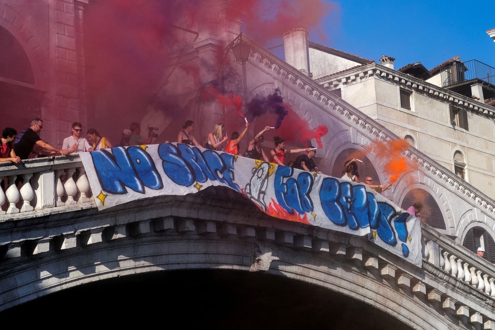 Demonstrators on the Rialto Bridge, hold smoke flares while standing by a banner that reads 'No space for Bezos' as they take part in a protest against Amazon founder Jeff Bezos, on the third day of Jeff Bezos and his wife Lauren Sanchez Bezos' wedding festivities, in Venice, Italy, June 28, 2025. REUTERS/Manuel Silvestri       TPX IMAGES OF THE DAY