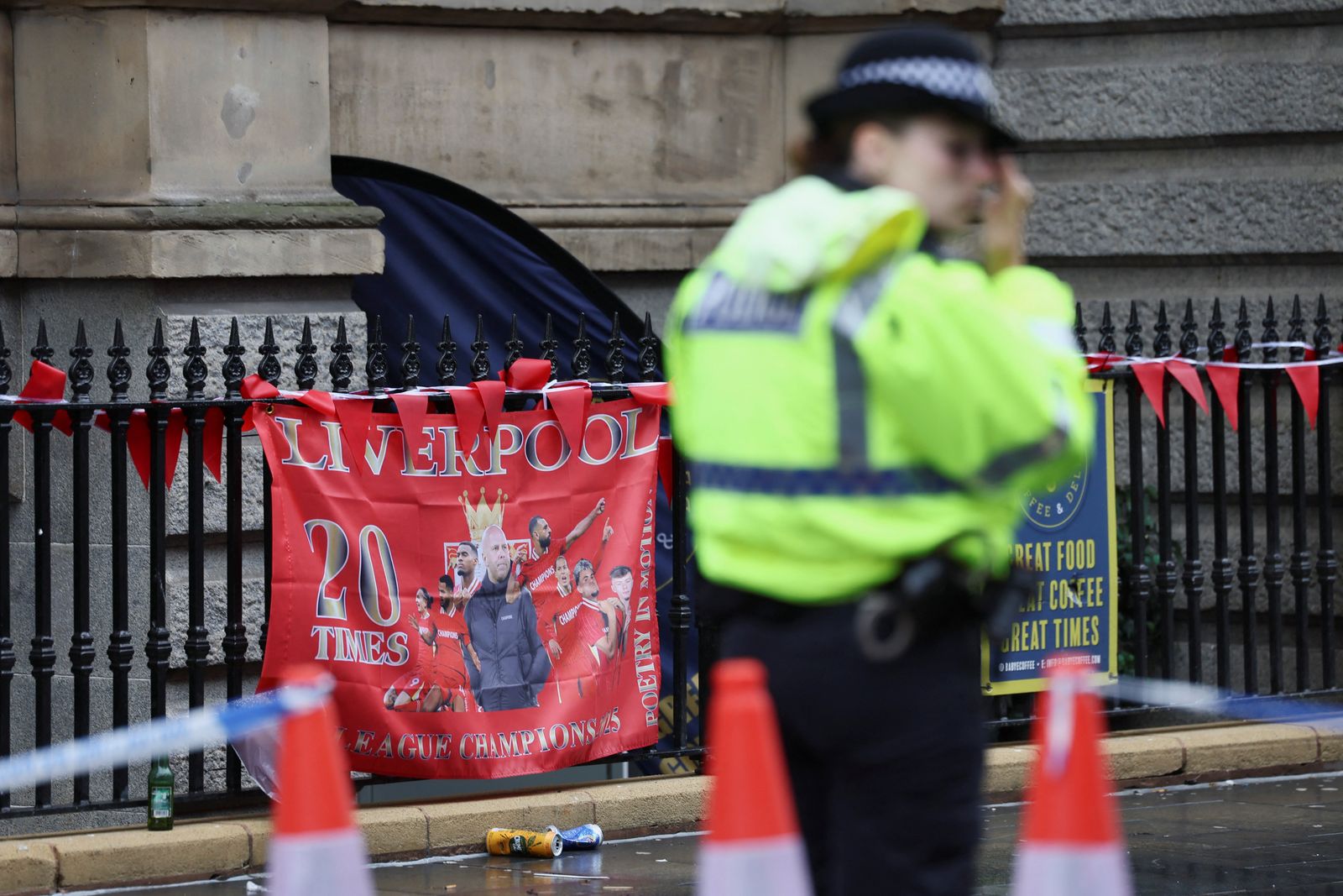A police officer stands guard as a Liverpool FC flag is seen in the background at the site of an incident where a car plowed into a crowd of Liverpool fans during a parade celebrating their side's Premier League soccer title, in central Liverpool, Britain, May 27, 2025. REUTERS/Isabel Infantes