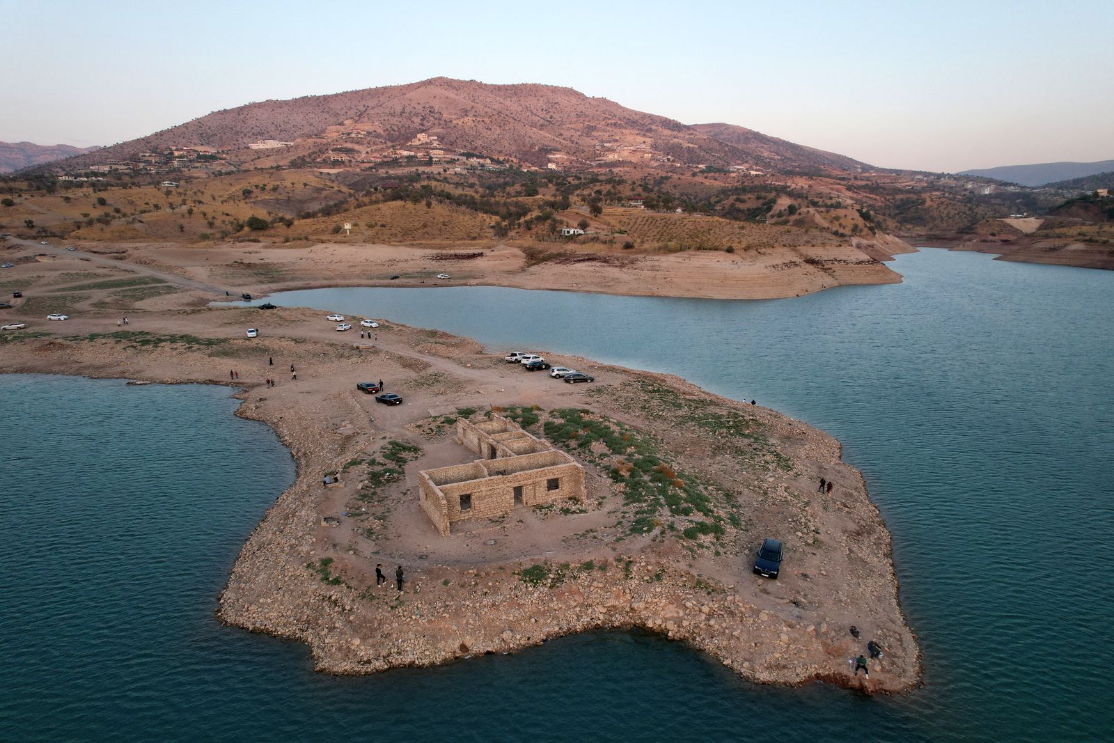 An aerial view shows the remains of the submerged Gary Qasruka village abandoned 36 years ago, which have resurfaced following a large drop in water level of the Dohuk Dam due to drought, in the northern Iraqi city of Dohuk in the autonomous Kurdish region on November 4, 2021. (Photo by Ismael ADNAN / AFP) - AFP