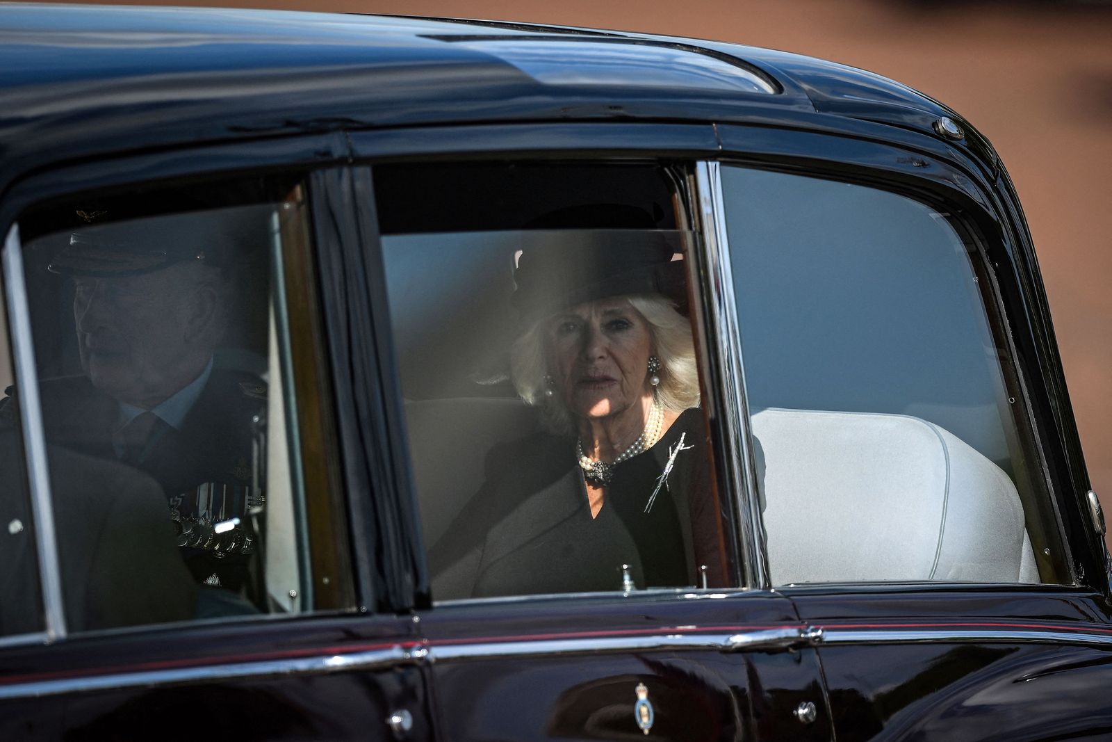 ملك بريطانيا تشارلز الثالث وقرينته الملكة كاميلا يعودان بالسيارة إلى قصر باكنجهام بعد حضور قداس لاستقبال نعش الملكة إليزابيث الثانية في قاعة وستمنستر بلندن- 14 سبتمبر 2022  - AFP
