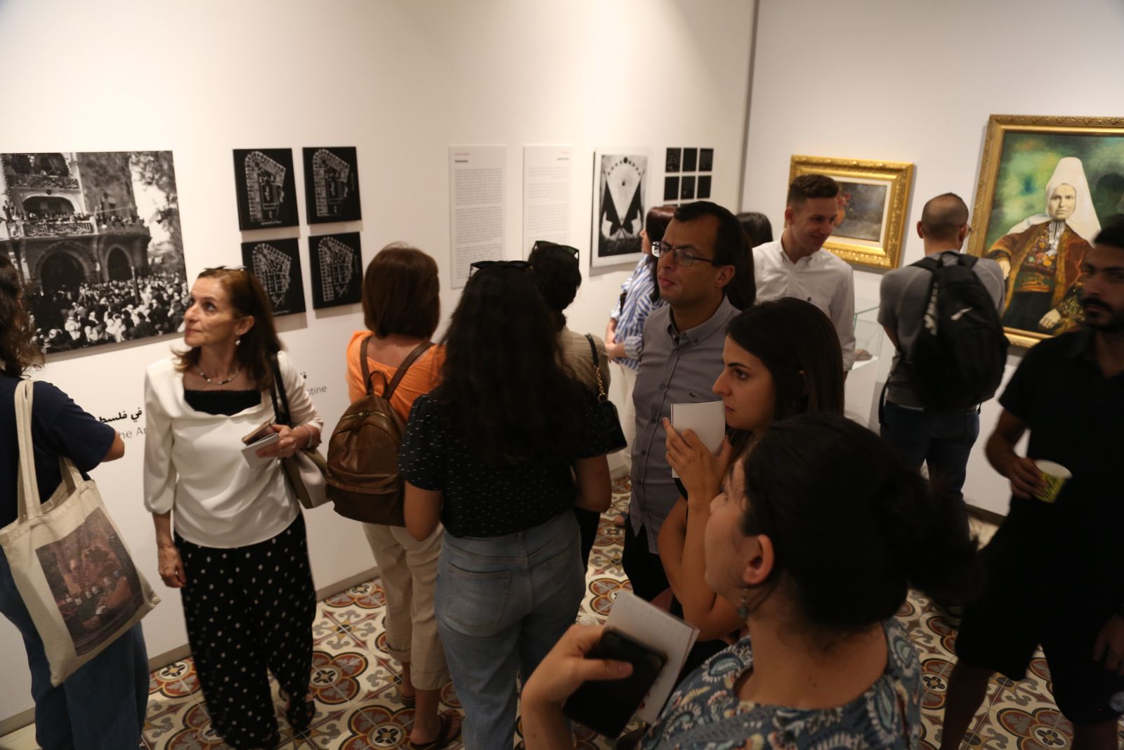 زوار في مركز خليل السكاكيني يتأملون لوحات 