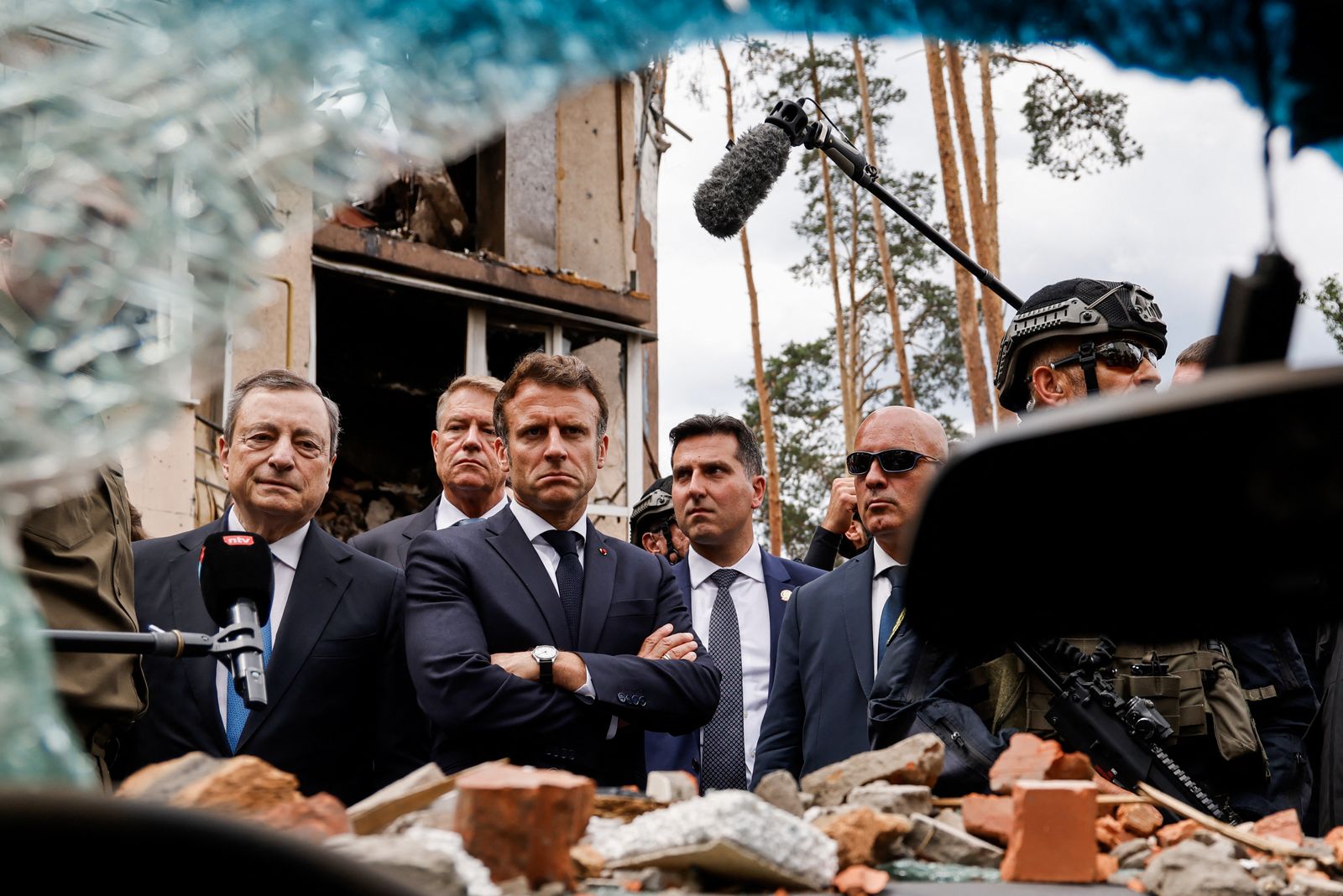 رئيس الوزراء الإيطالي ماريو دراجي (يسار) والرئيس الفرنسي إيمانويل ماكرون (وسط) وخلفه الرئيس الروماني كلاوس يوهانيس  بينما لا يظهر المستشار الألماني أولاف شولتز ينظرون إلى آثار القصف الروسي في زيارة إلى ضاحية إربين بالعاصمة الأوكرانية كييف. 16 يونيو 2022 - AFP