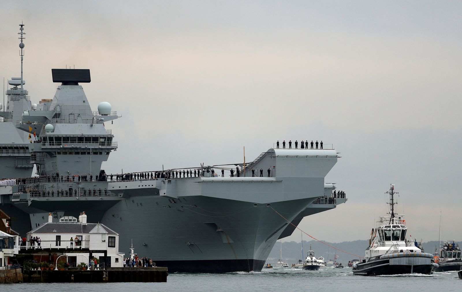 حاملة الطائرات البحرية الملكية، HMS Queen Elizabeth، يتم سحبها بواسطة القاطرات عند وصولها إلى قاعدة بورتسموث البحري ، بريطانيا. 16 أغسطس 2017 - REUTERS
