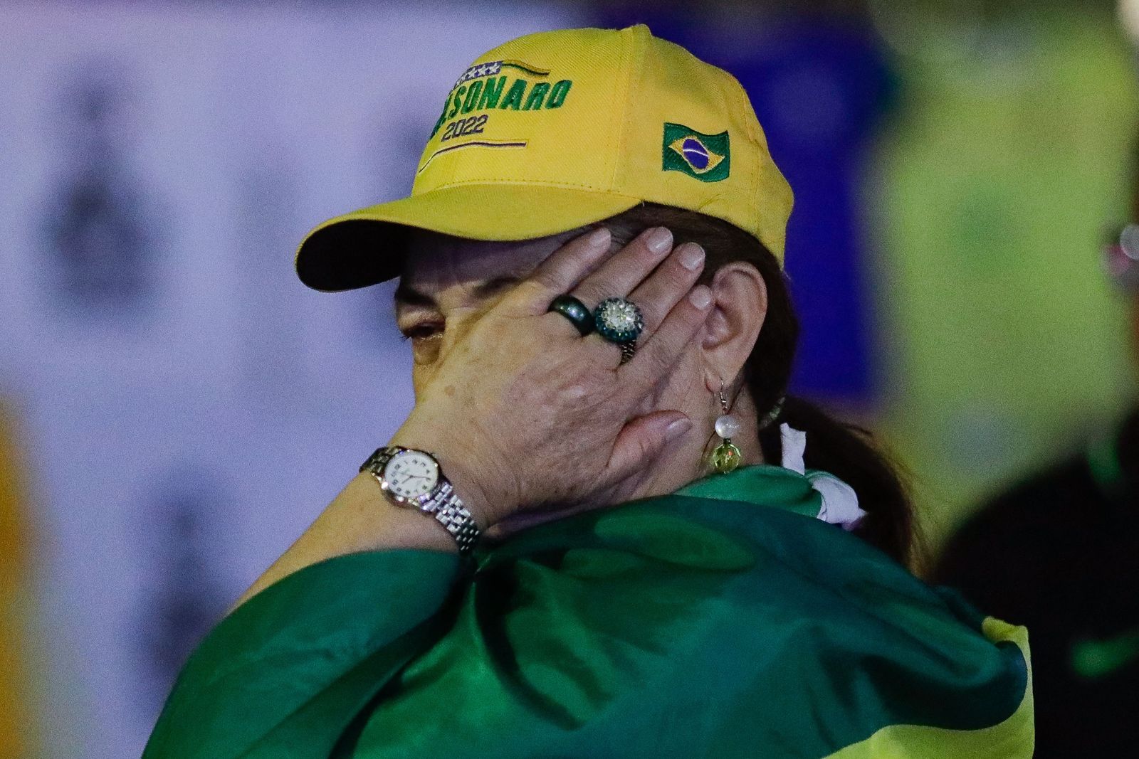 A supporter of Brazilian President and re-election candidate Jair Bolsonaro cries after the vote count of the legislative and presidential election, in Brasilia, Brazil, on October 2, 2022. - Brazil's bitterly divisive presidential election will go to a runoff on October 30, electoral authorities said Sunday, as incumbent Jair Bolsonaro beat expectations to finish a relatively close second to front-runner Luiz Inacio Lula da Silva. (Photo by Sergio Lima / AFP) - AFP