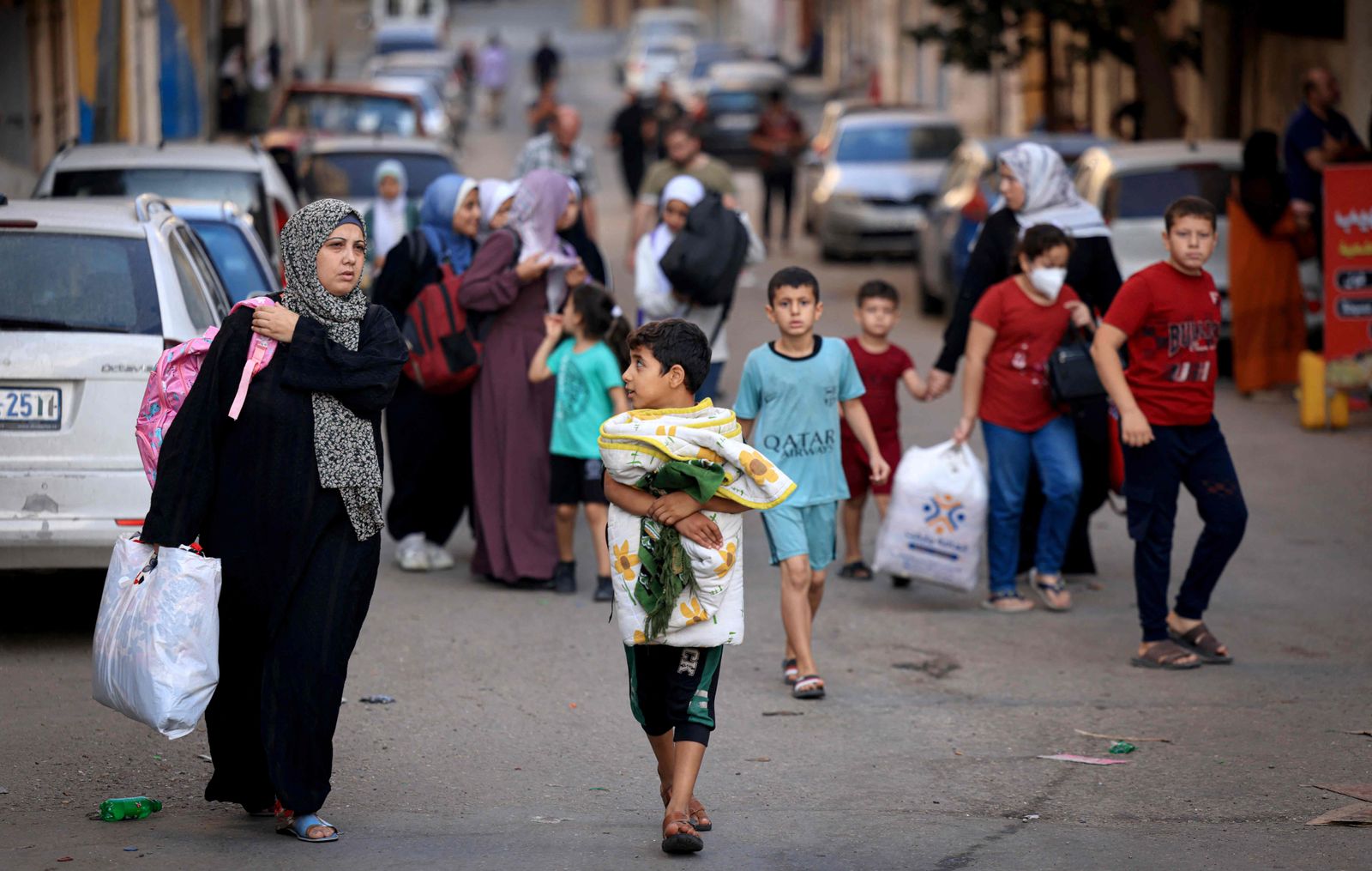 Palestinians carrying their belongings flee to safer areas in Gaza City after Israeli air strikes, on October 13, 2023. Israel has called for the immediate relocation of 1.1 million people in Gaza amid its massive bombardment in retaliation for Hamas's attacks, with the United Nations warning of 'devastating' consequences. (Photo by MAHMUD HAMS / AFP)