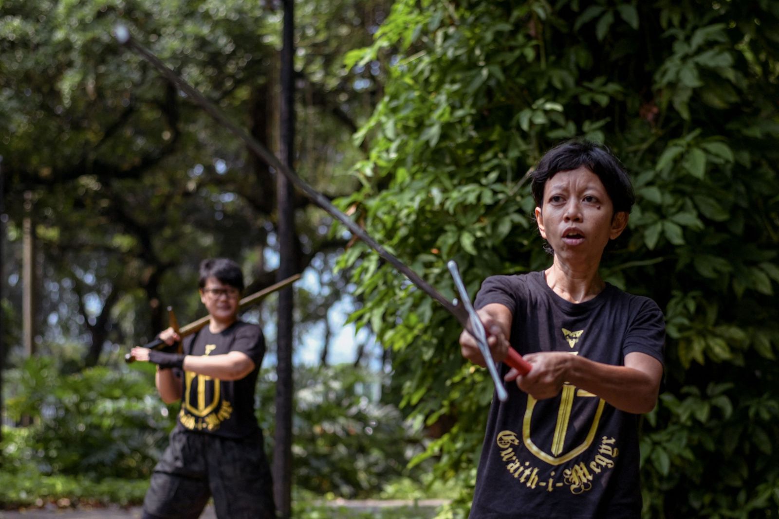 This picture taken on July 24, 2022 shows members of the Gwaith-i-Megyr group practicing sword-fighting techniques known as Historical European Martial Arts (HEMA) at a park in Jakarta. - Armed with blunt swords, a dozen would-be chevaliers are put through their paces in a gallant effort to keep alive European medieval martial arts taught hundreds of years ago. (Photo by BAY ISMOYO / AFP) / To go with AFP story Indonesia-lifestyle-hobby by Marchio GORBIANO - AFP