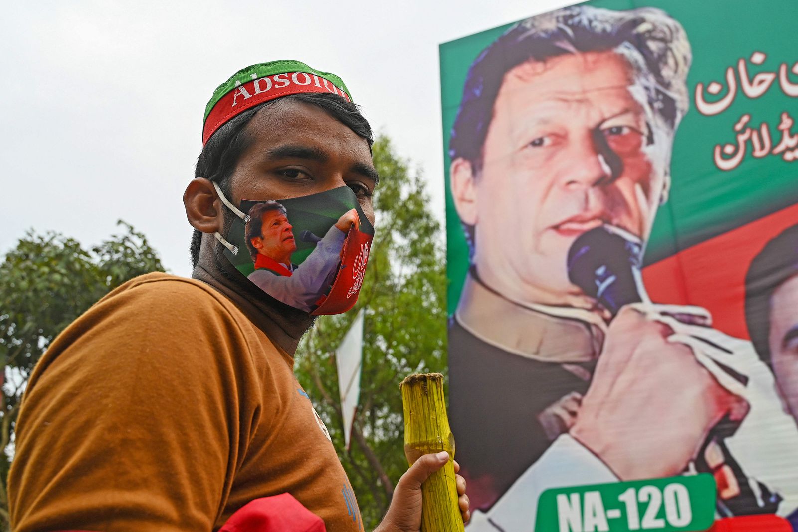 A supporter of Pakistan's former Prime Minister Imran Khan guards Khan's residence in Lahore on March 17, 2023. - A Pakistan court declined on March 16 to cancel an arrest warrant for former prime minister Imran Khan, one of his lawyers said, as hundreds of his supporters held a vigil at his home and vowed to stop police from detaining him. (Photo by Aamir QURESHI / AFP)