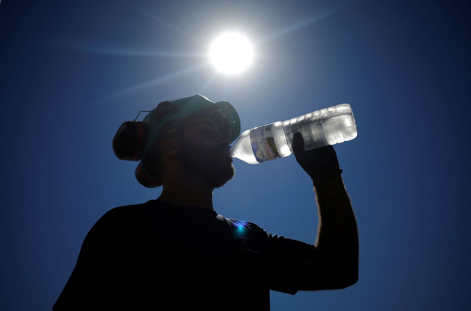 A worker drinks water on a road site in Aigrefeuille-sur-Maine - REUTERS