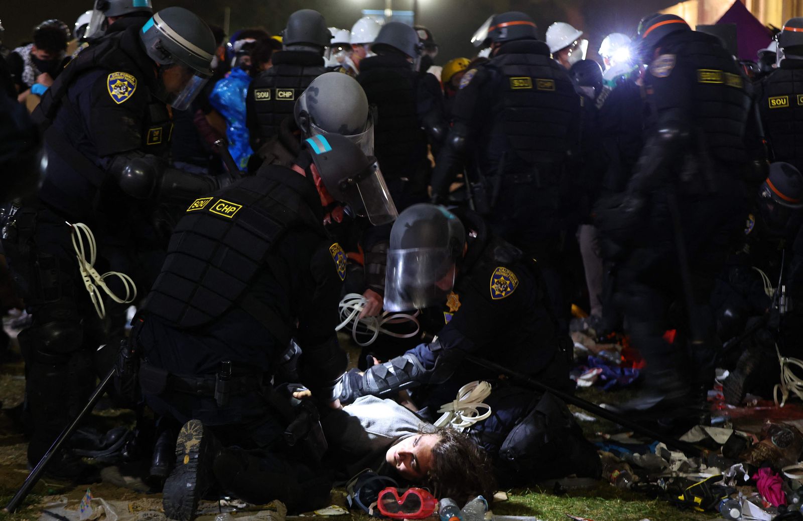 LOS ANGELES, CALIFORNIA - MAY 02: California Highway Patrol (CHP) officers detain a protestor while clearing a pro-Palestinian encampment after dispersal orders were given at the University of California, Los Angeles (UCLA) campus, on May 2, 2024 in Los Angeles, California. The camp was declared �unlawful� by the university and over 100 protestors who refused to leave were detained during the operation. Pro-Palestinian encampments have sprung up at college campuses around the country with some protestors calling for schools to divest from Israeli interests amid the ongoing war in Gaza.   Mario Tama/Getty Images/AFP (Photo by MARIO TAMA / GETTY IMAGES NORTH AMERICA / Getty Images via AFP)