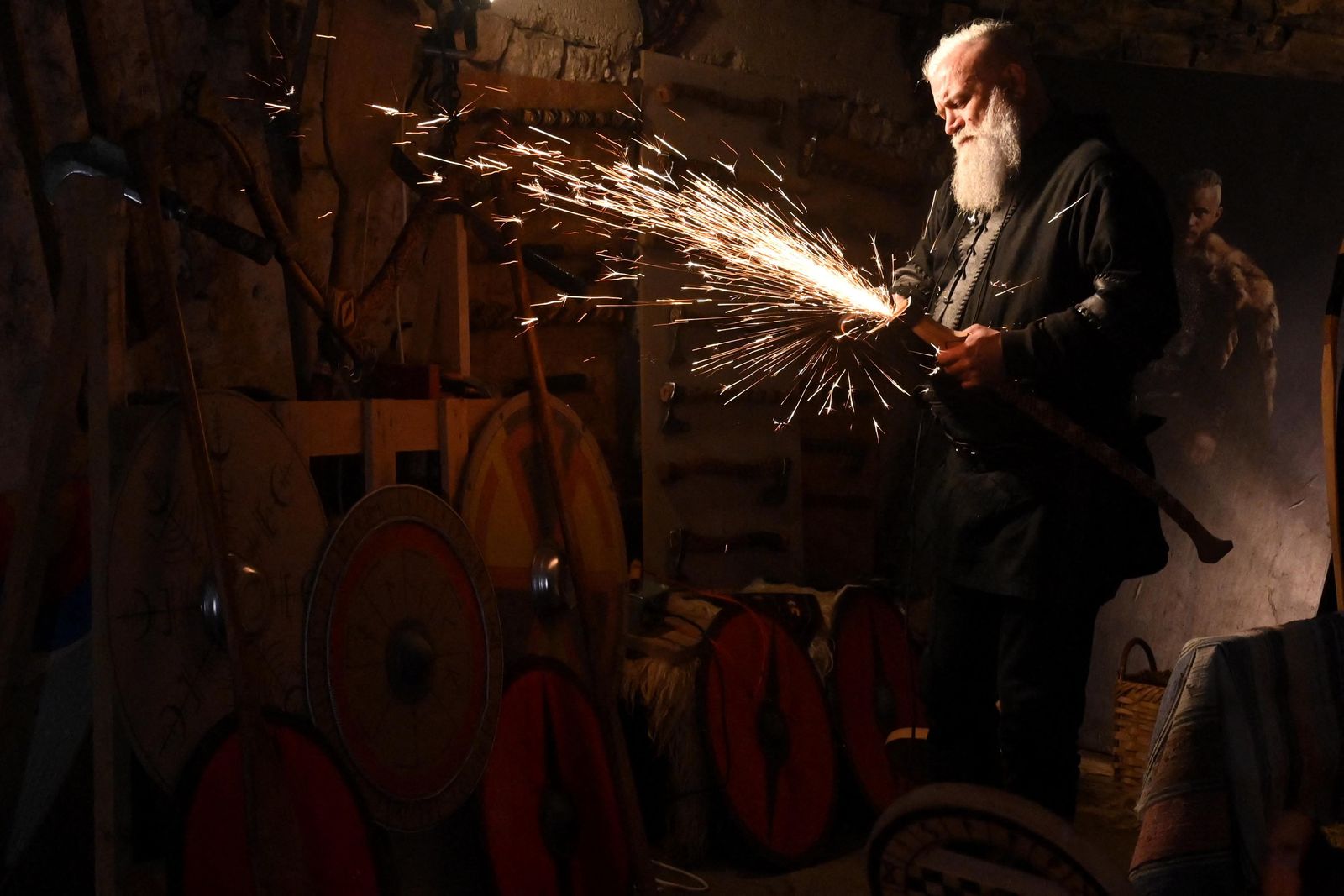 Stipe Pleic, also known by his Viking nickname of Ragnar Kavurson, works the metal head  of a 'viking weapon', in the western-Bosnian town of Tomislavgrad on January 5, 2022. - Some 6 years ago, Pleic developed fascination for Nordic culture and history. Since than he used his previous knowledge and experience in metal and wood work and started crafting traditional Viking axes and knives. He retreated to his father's old stone house where he established his workshop and somewhat of a Viking armaments museum. According to Pleic, in his workshop, he finds a little peace and escape from harsh reality of life in Bosnia and Herzegovina. (Photo by ELVIS BARUKCIC / AFP) - AFP