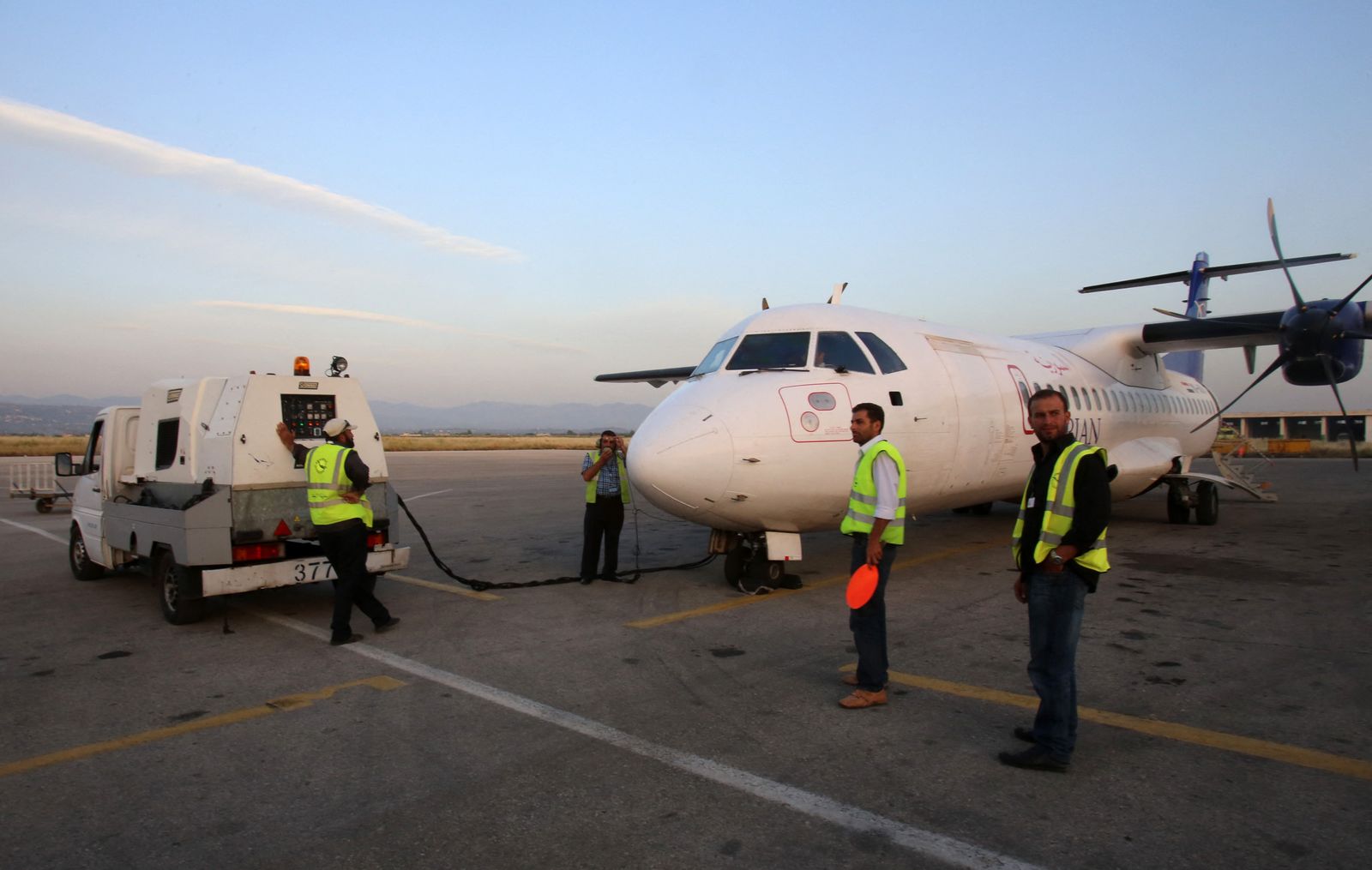 Syrian technicians work on a Syrian airplane, coming from the northern Syrian province of Qamishli, on May 24, 2015 at al-Basel International Airport in the coastal city of Latakia. AFP PHOTO / YOUSSEF KARWASHAN (Photo by YOUSSEF KARWASHAN / AFP) - AFP