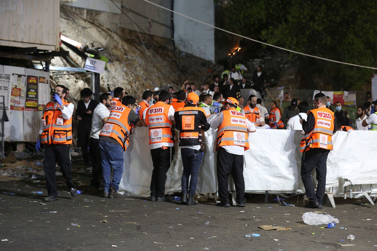 عمال الطوارئ يتجمعون في مكان الحادث بعد مقتل العشرات وإصابة آخرين بعد انهيار مدرج أثناء الاحتفال بعيد الشعلة اليهودي في الجليل - AFP