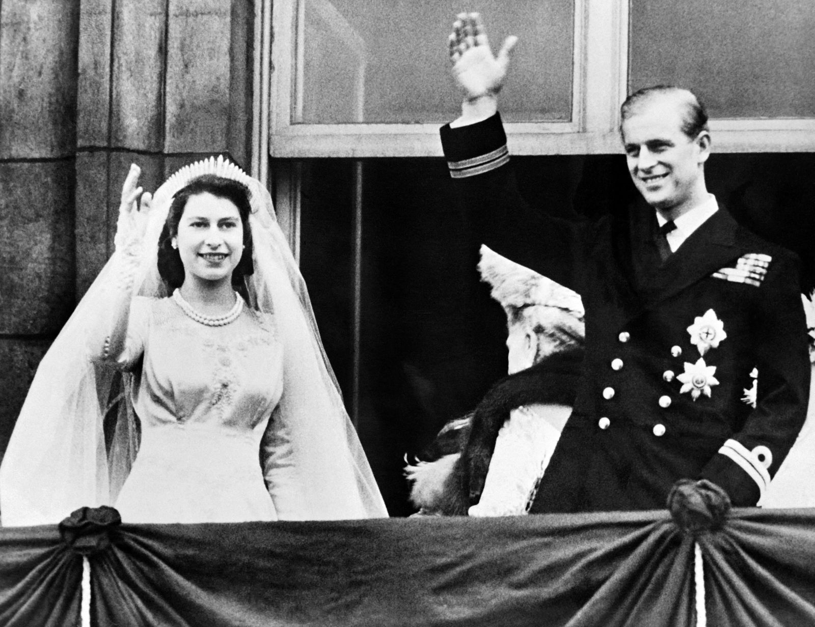 الملكة تلوح إليزابيث الثانية والأمير فيليب ، دوق إدنبرة، في حفل زفافهما في العام 1947 - AFP