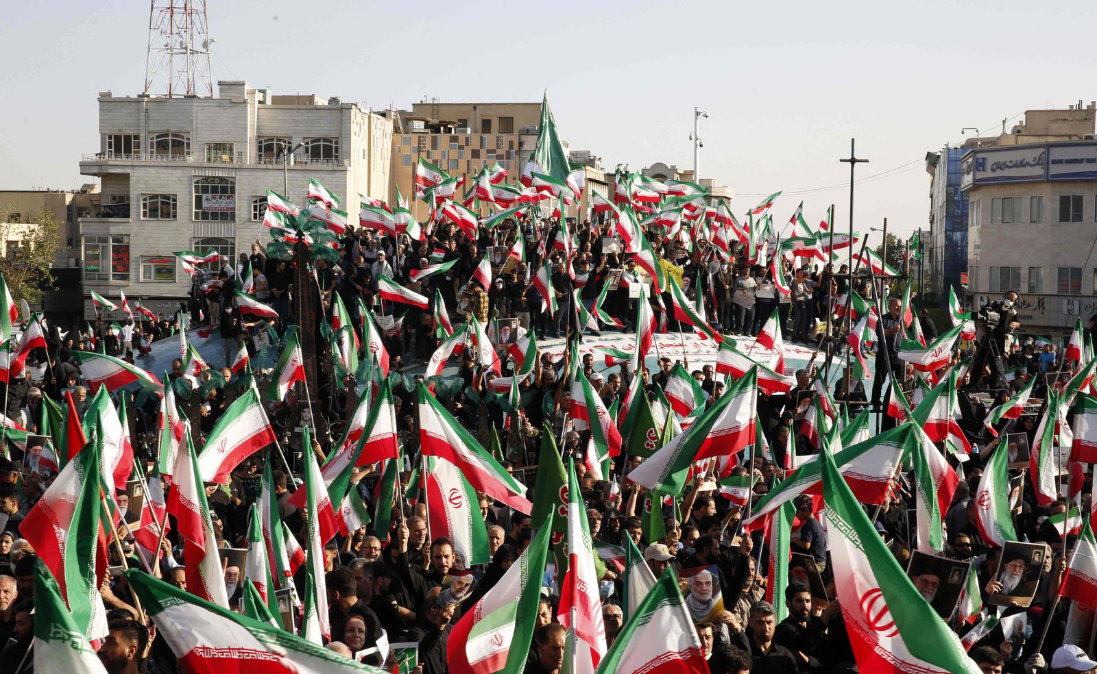 متظاهرون إيرانيون موالون للحكومة يلوحون بأعلامهم الوطنية خلال مسيرة ضد الاحتجاجات المناهضة للنظام في إيران، طهران - 25 سبتمبر 2022 - AFP