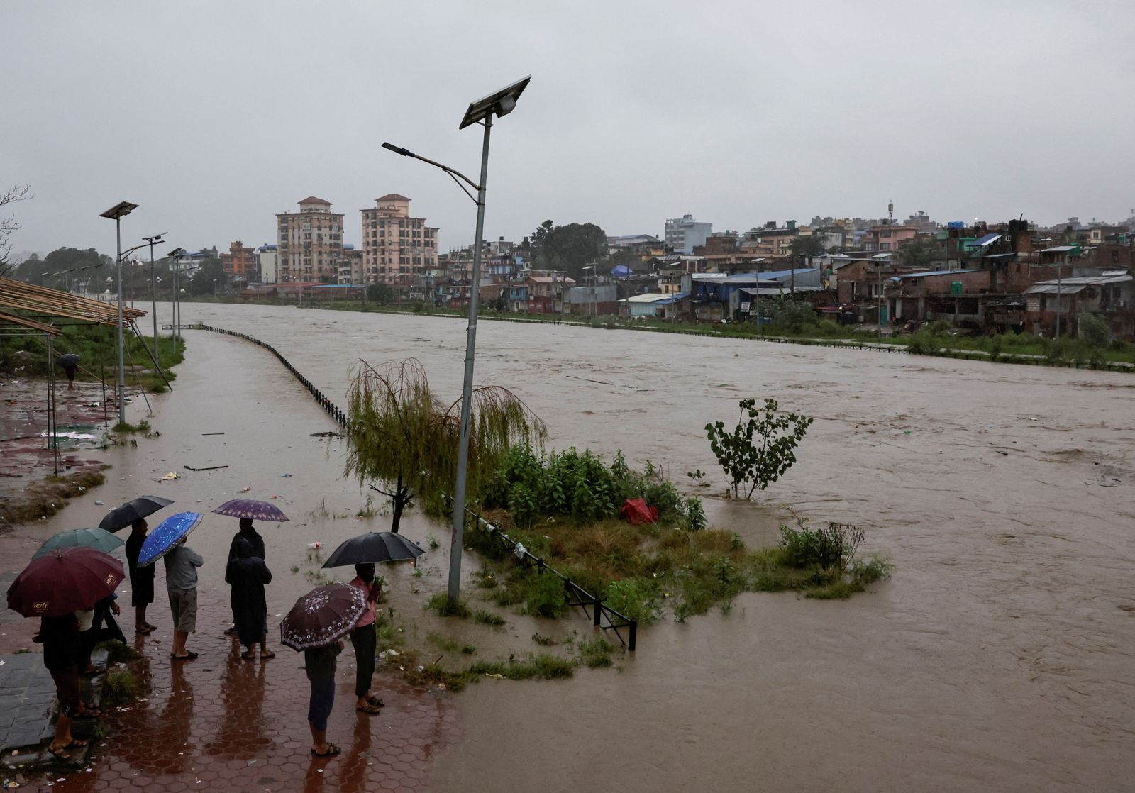People look towards the overflowing Bagmati River following heavy rains, in Kathmandu, Nepal, October 4, 2025. REUTERS/Navesh Chitrakar
