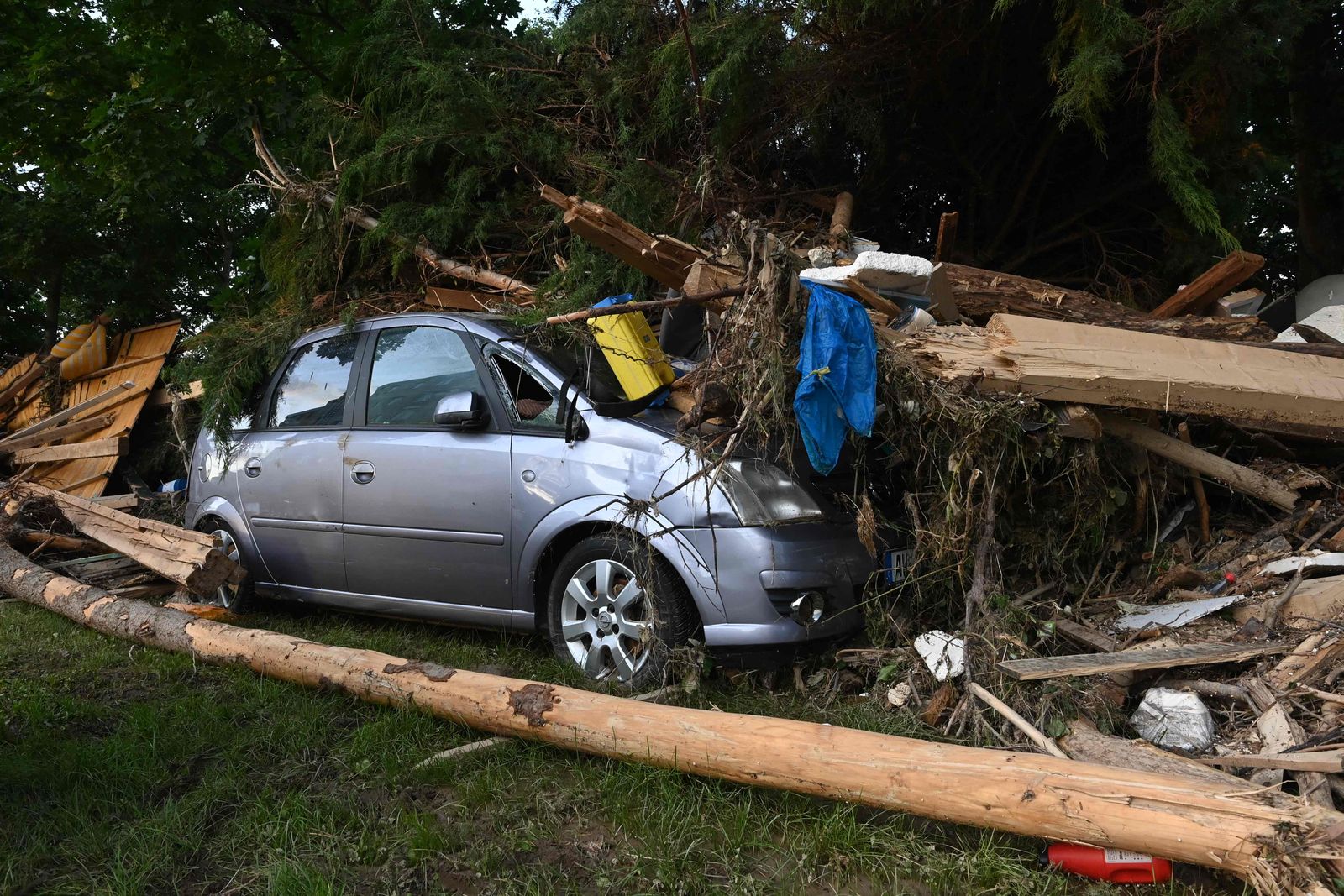 A damaged car can be seen under torn trees and debris in Bad Neuenahr-Ahrweiler, western Germany, on July 17, 2021. - Devastating floods in Germany and other parts of western Europe have been described as a 
