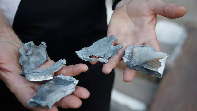 رجل يعرض شظايا قذيفة من عيار 155 ملم عثر عليها بالقرب من مبنى سكني بمنطقة سكنية في دونيتسك. - ريا نوفوستي